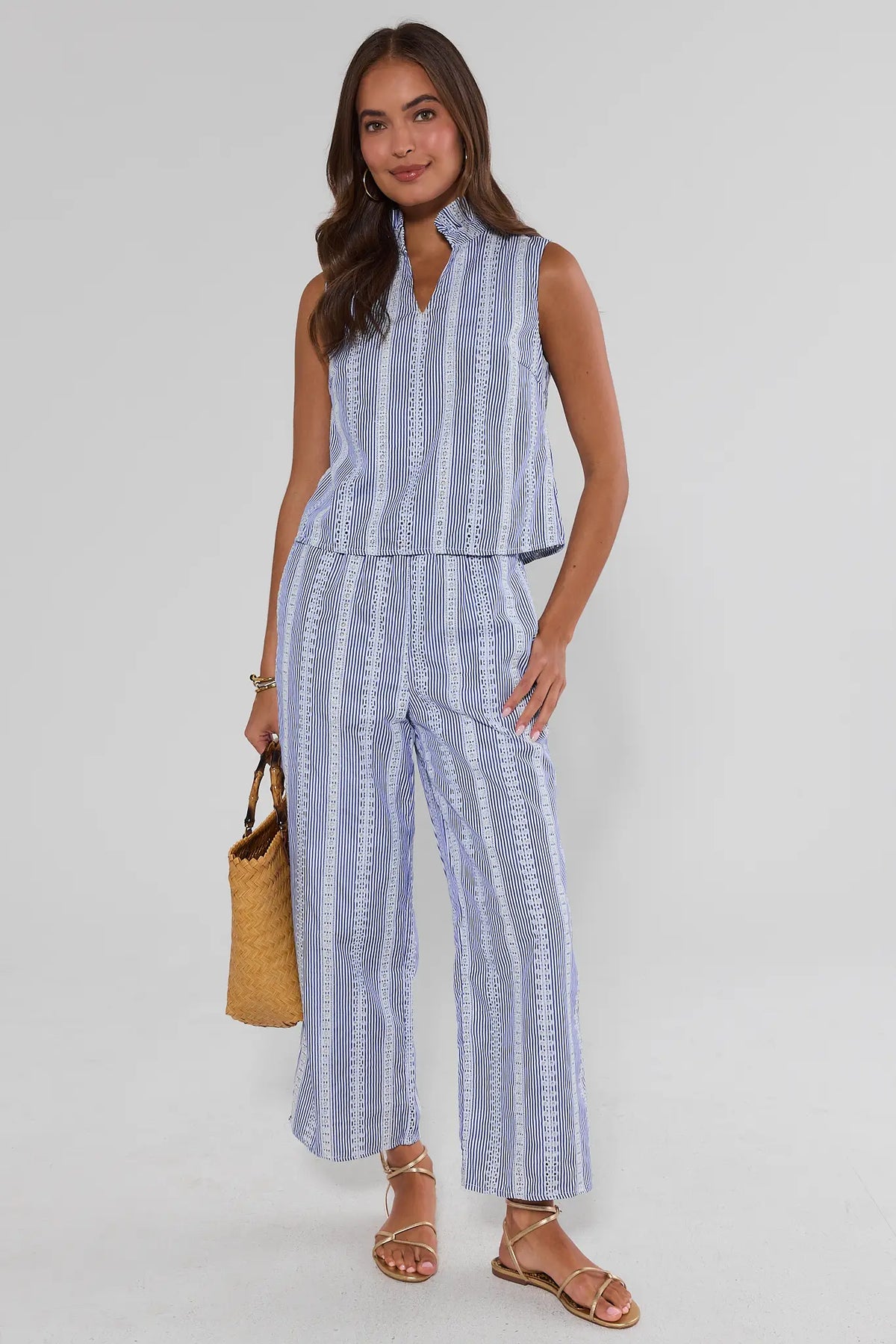 Blue stripe embroidered pants worn as a matching set with woven bag, on model full-length front view | Avara