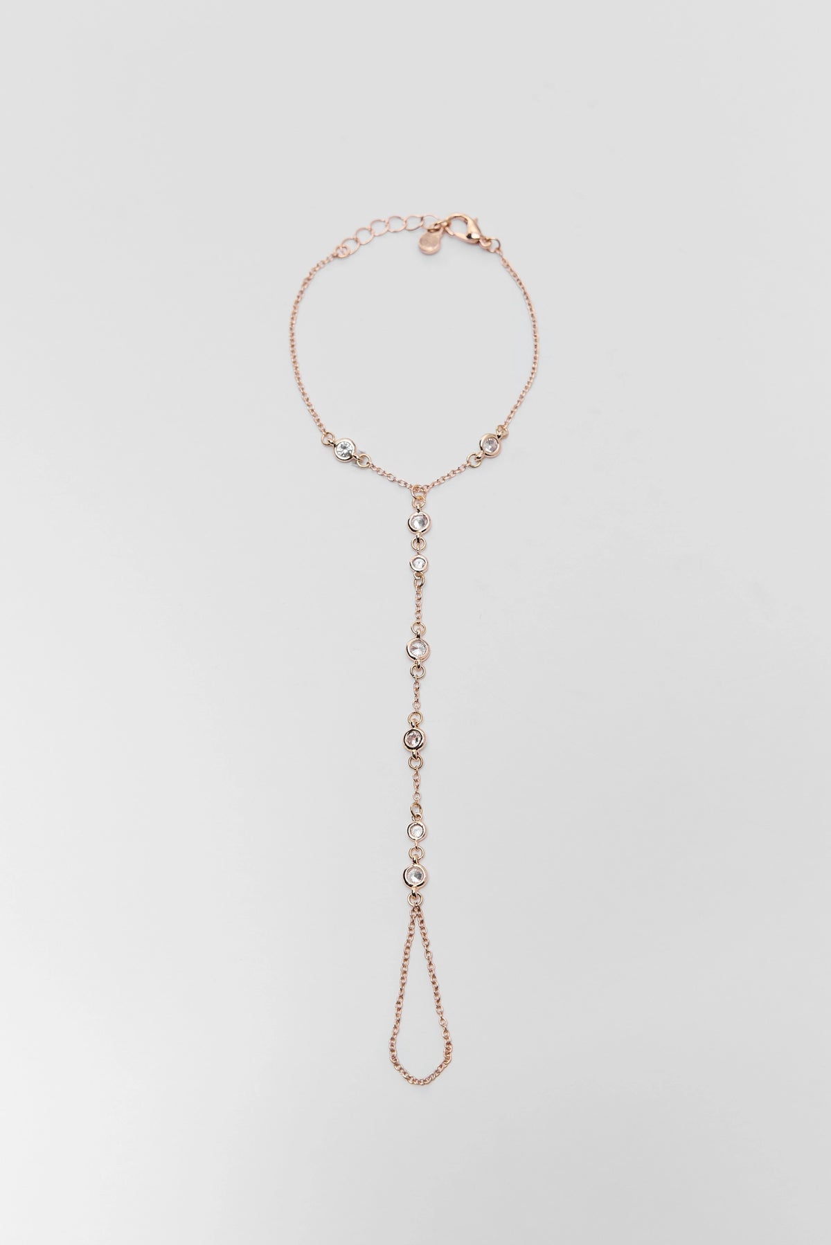 Gold rhinestone hand chain bracelet with finger loop - Flat Lay | Avara