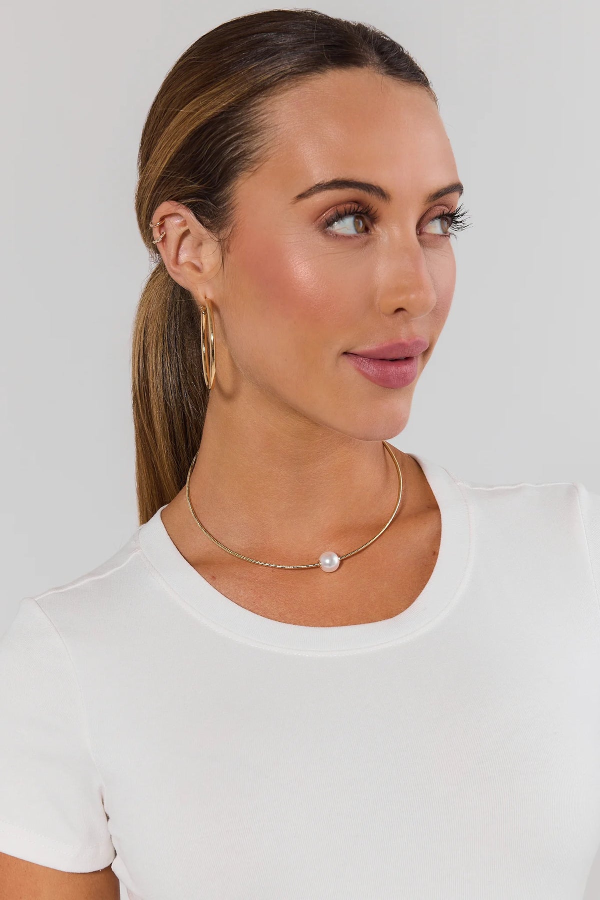 Woman wearing gold pearl charm necklace on herringbone chain - On Model | Avara