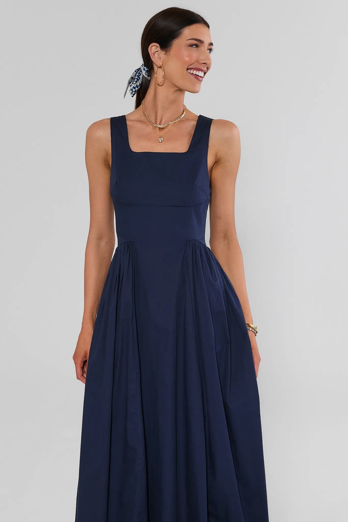 Navy gathered maxi dress with square neckline and flowy skirt, front view on model | Avara