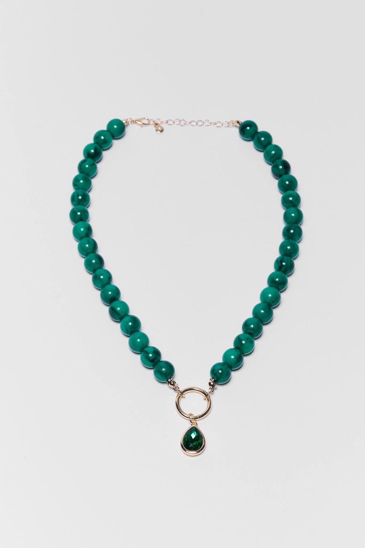 Teal green beaded drop necklace with gold ring pendant and rhinestone - Flat Lay | Avara
