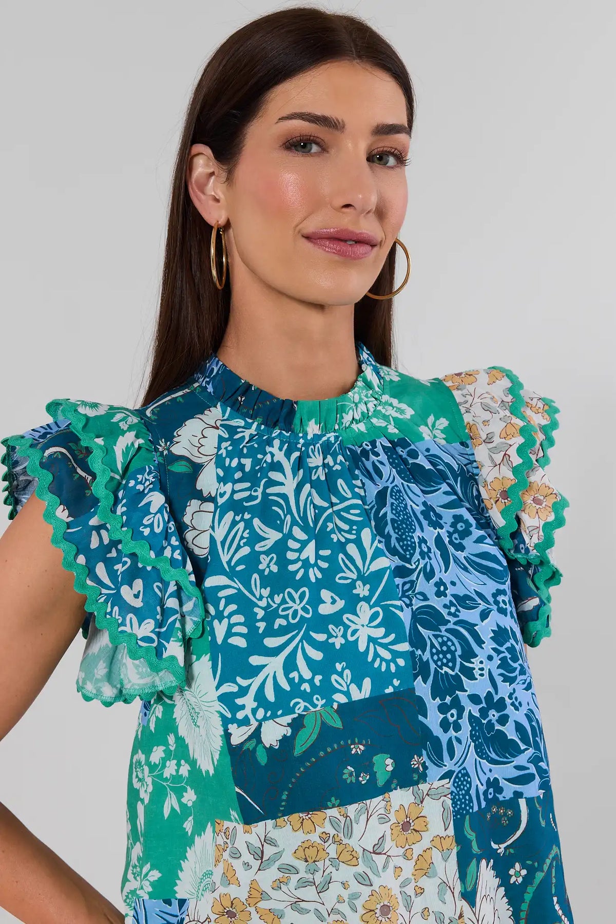 Green Multi Patchwork Print Top, close-up detail of mock neck and ric-rac ruffle sleeves, on model | Avara