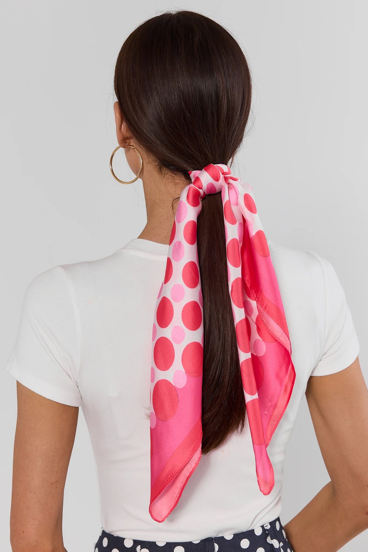 woman wearing Pink Multi Polka Dot Scarf tied in ponytail, back view on model | Avara