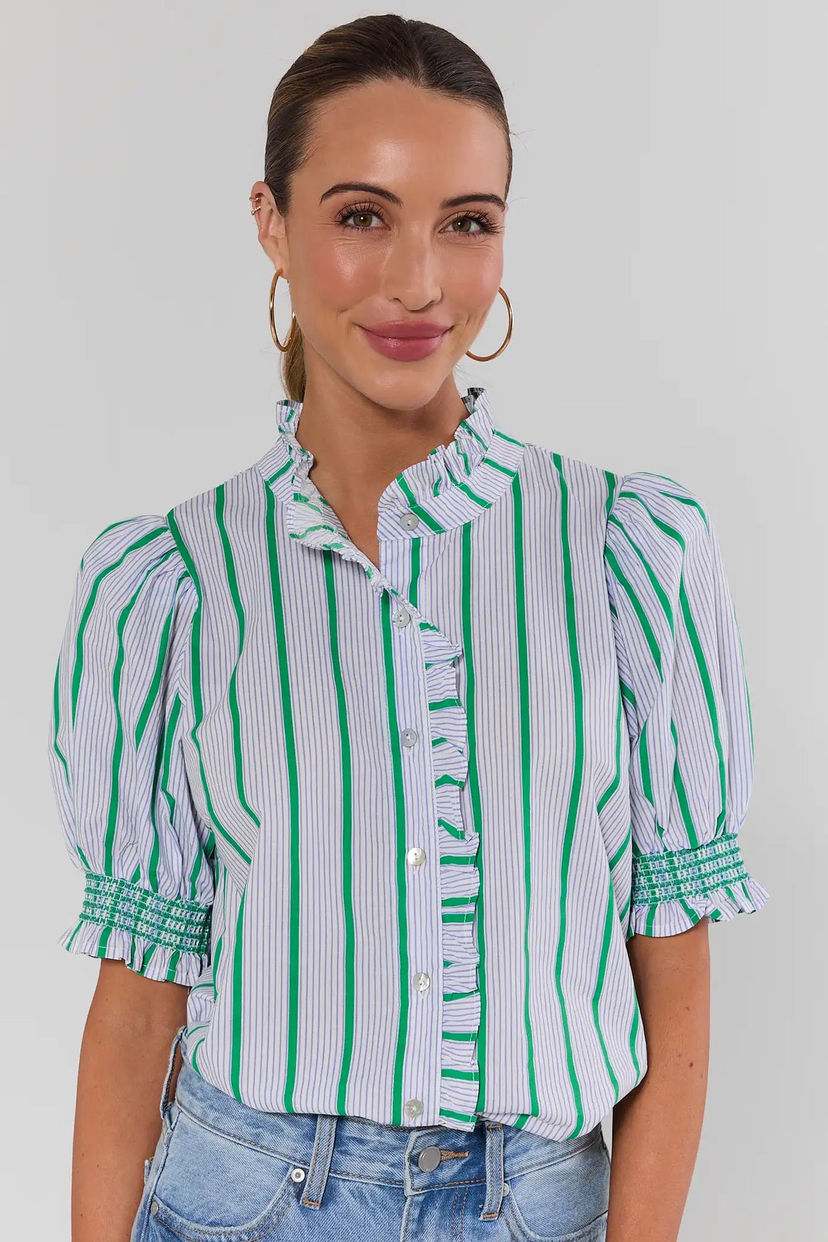 Green striped ruffle button-up top on model styled with light wash denim, front on-model view | Avara