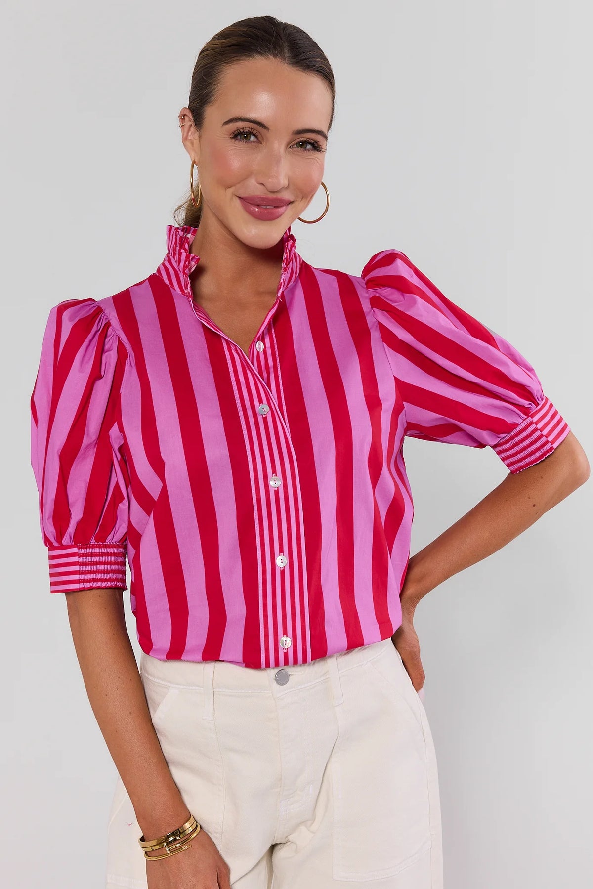 Pink and red striped puff-sleeve button-up top with ruffled collar, front view on model | Avara