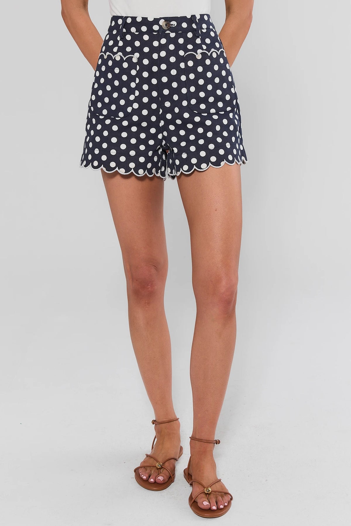 Navy and white polka dot scalloped shorts front view on model with tan strappy sandals | Avara
