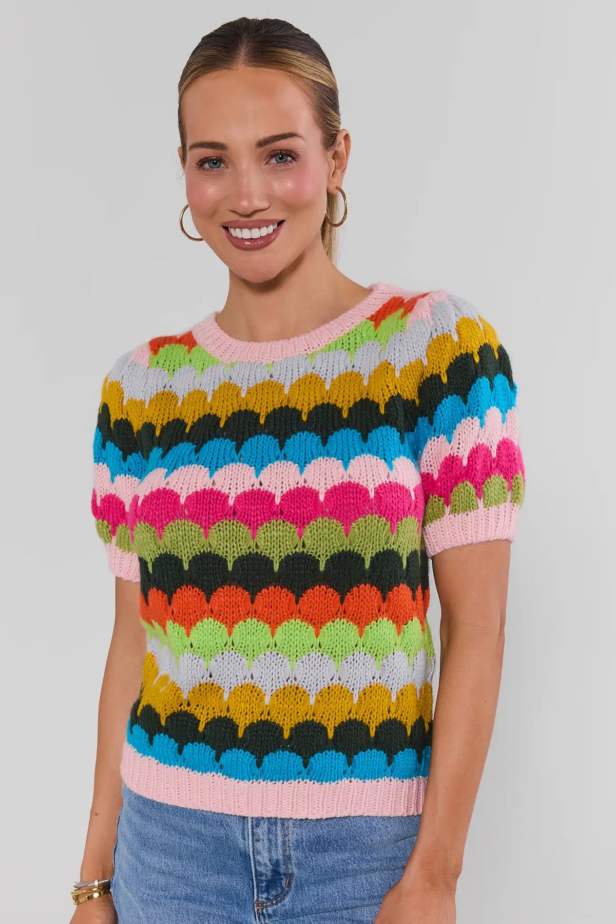 Woman wearing Trina Multi Striped Knit Top with blue jeans - Front View, colorful scallop stripe knit top for women | Avara