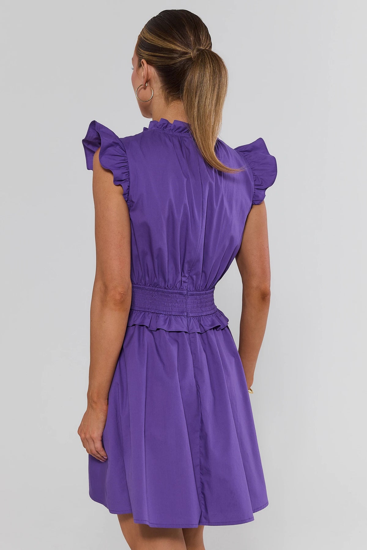 Makayla Purple Flutter Sleeve Short Dress back view showing smocked waistband, ruffle hem, and flutter sleeves | Avara
