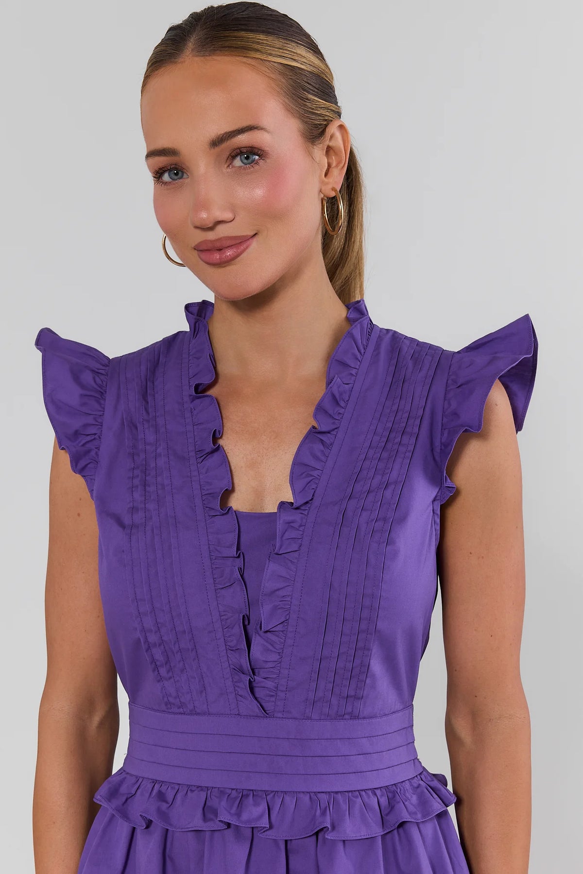 Makayla Purple Flutter Sleeve Short Dress close-up showing pintuck pleats, ruffle V-neckline, and flutter sleeves | Avara