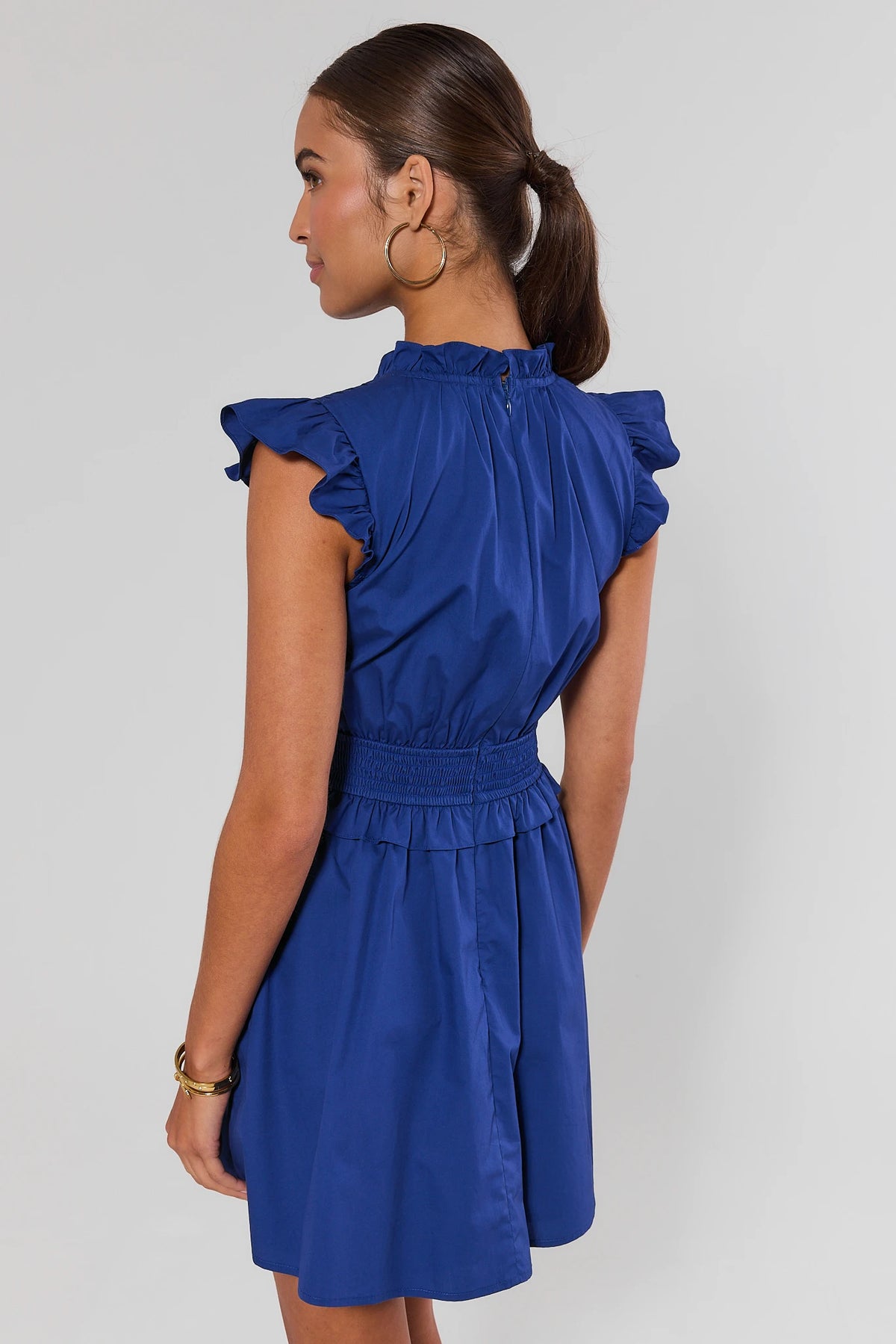 Makayla Blue Flutter Sleeve Short Dress back view showing flutter sleeves, smocked waist, zipper closure | Avara