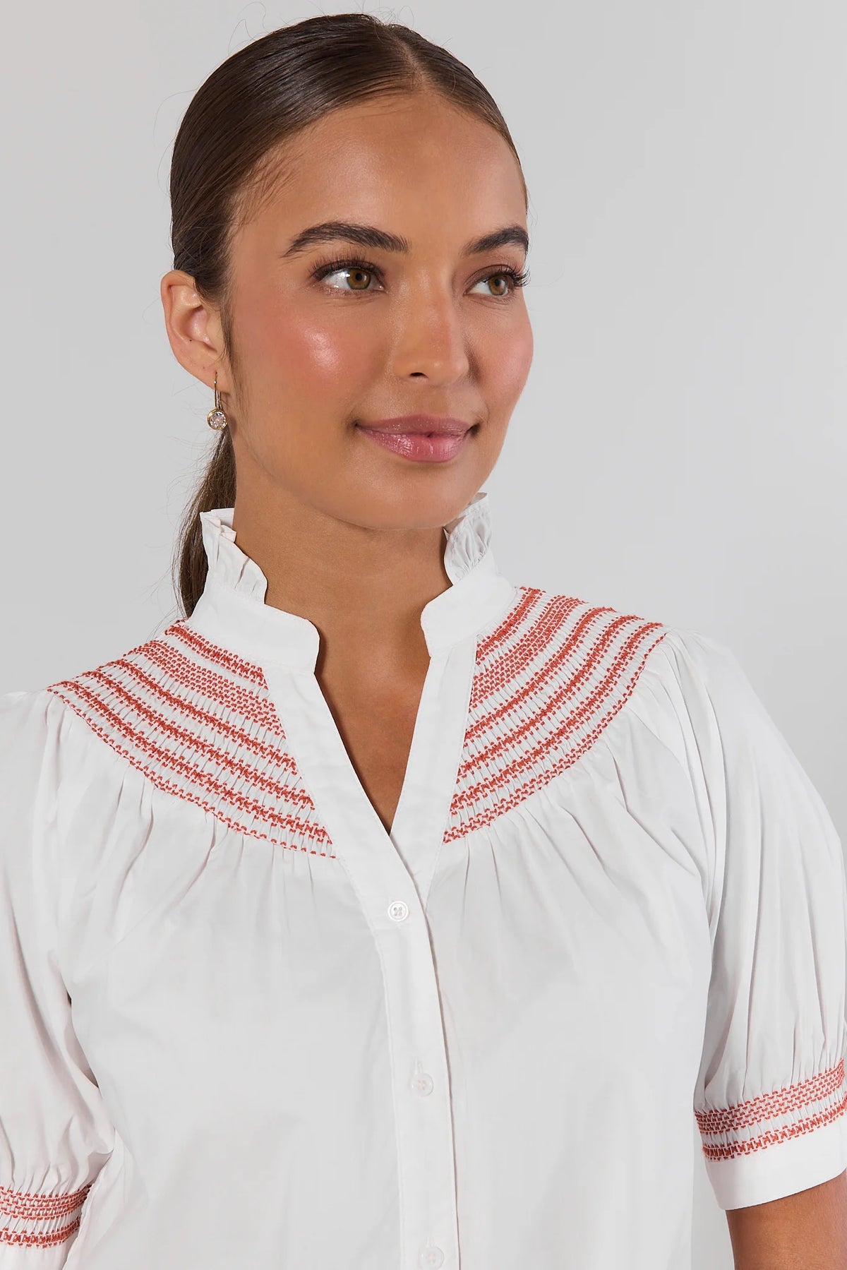 Yvonne White and Rust Embroidered Top close-up of rust smocked yoke, ruffle neckline, and embroidered cuff detail | Avara