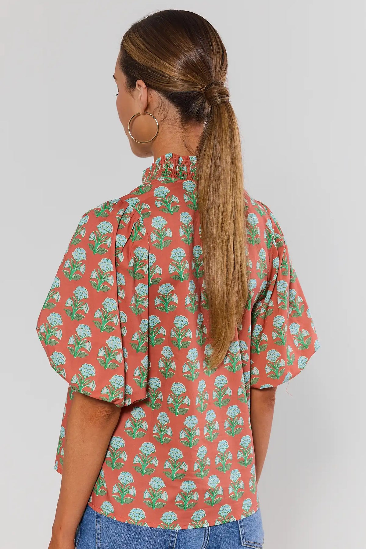 Back view of THML orange floral printed puff sleeve top with smocked neckline and allover block print | Avara