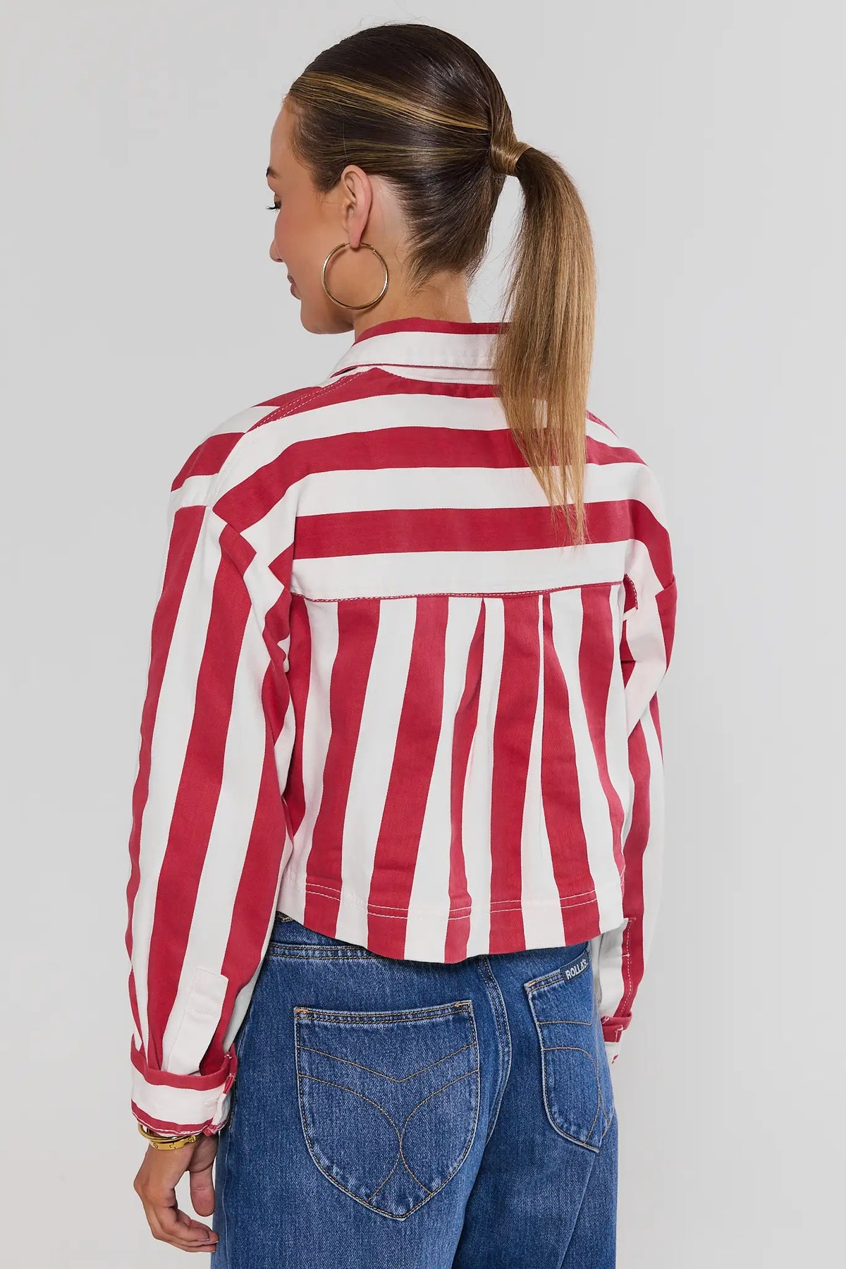 Red striped cropped jacket back view showing stripe pattern and cropped hem over blue jeans | Avara