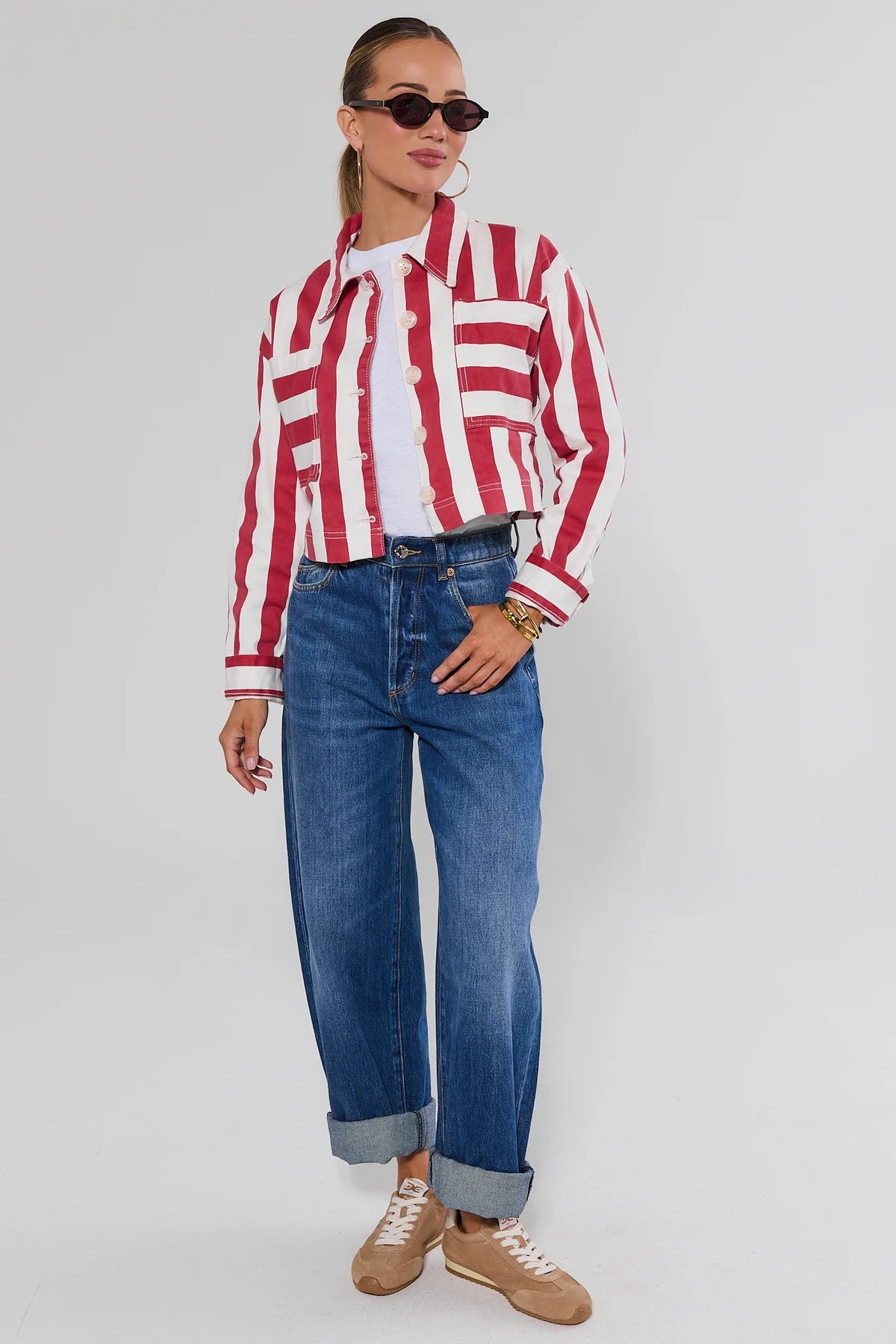 Red and white striped cropped jacket styled with wide-leg jeans and tan sneakers, full-length view | Avara