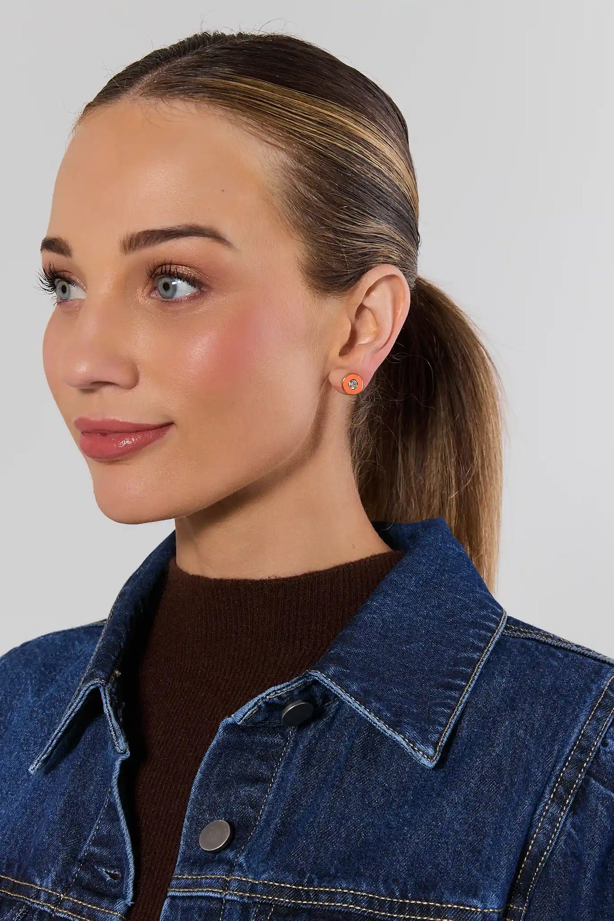 Orange enamel rhinestone stud earrings worn on model with denim jacket - game day look | Avara