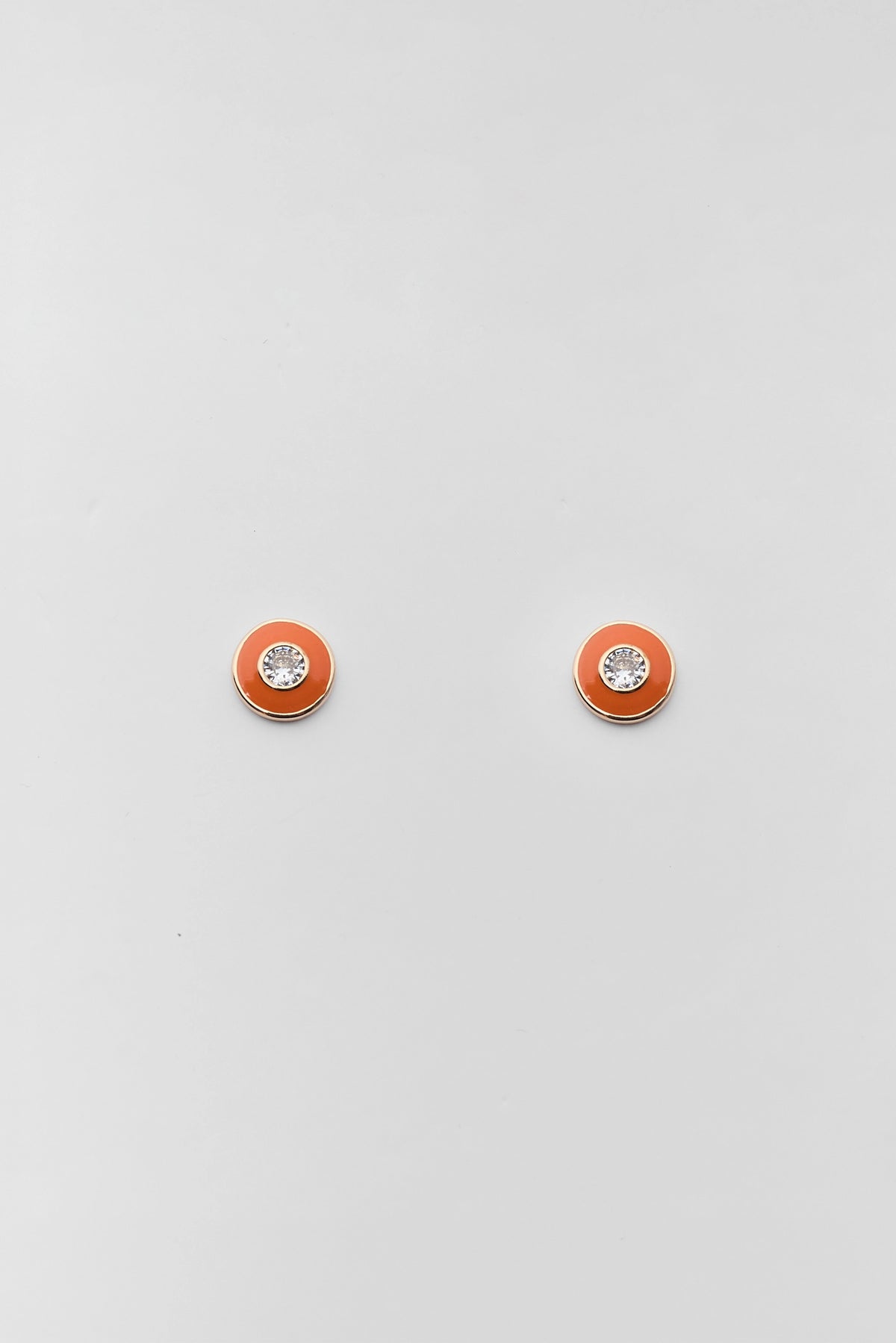 Orange enamel rhinestone stud earrings with gold-tone bezel and crystal center - Flat Lay | Avara