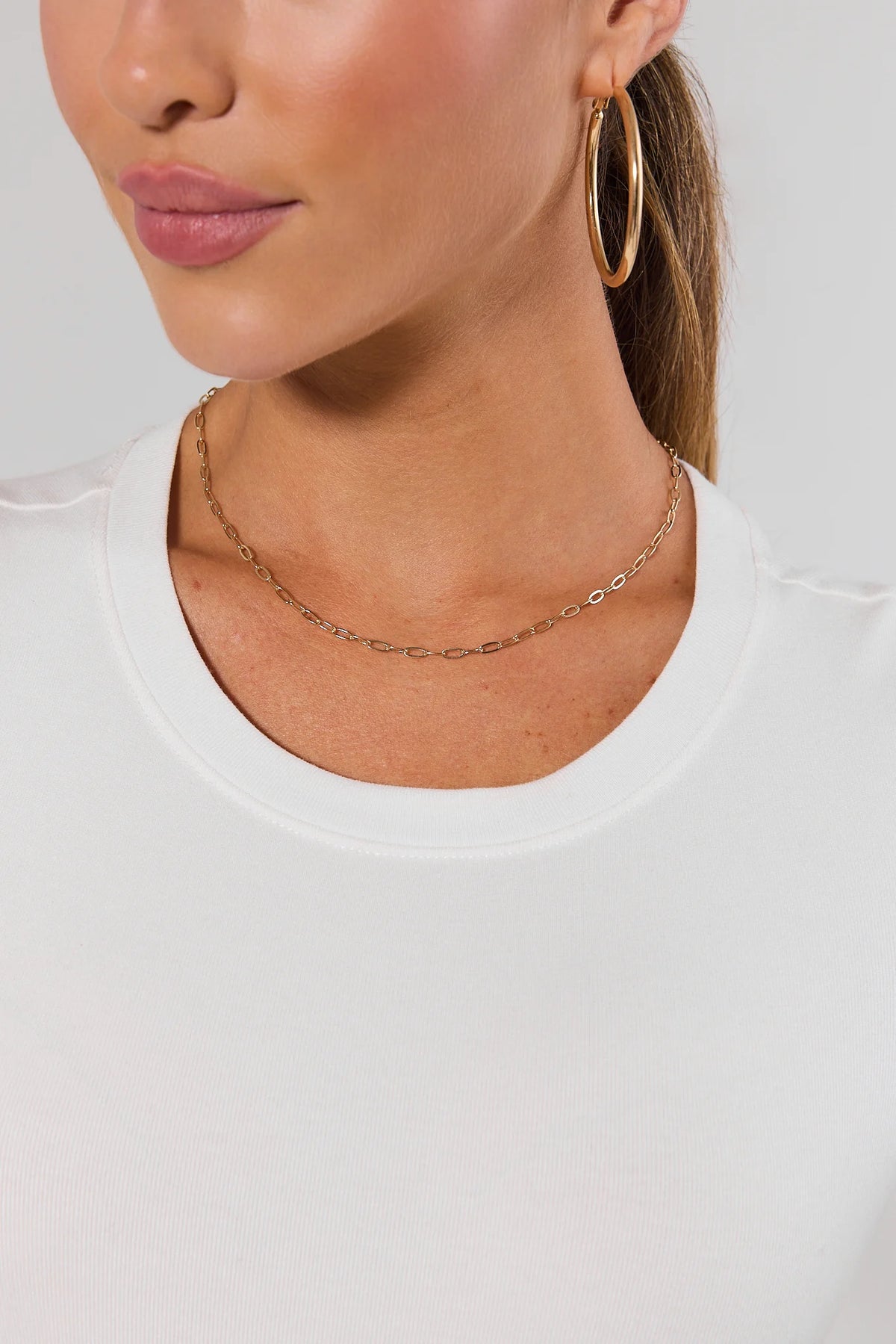 Woman wearing dainty gold paperclip chain necklace with gold hoop earrings - On Model | Avara