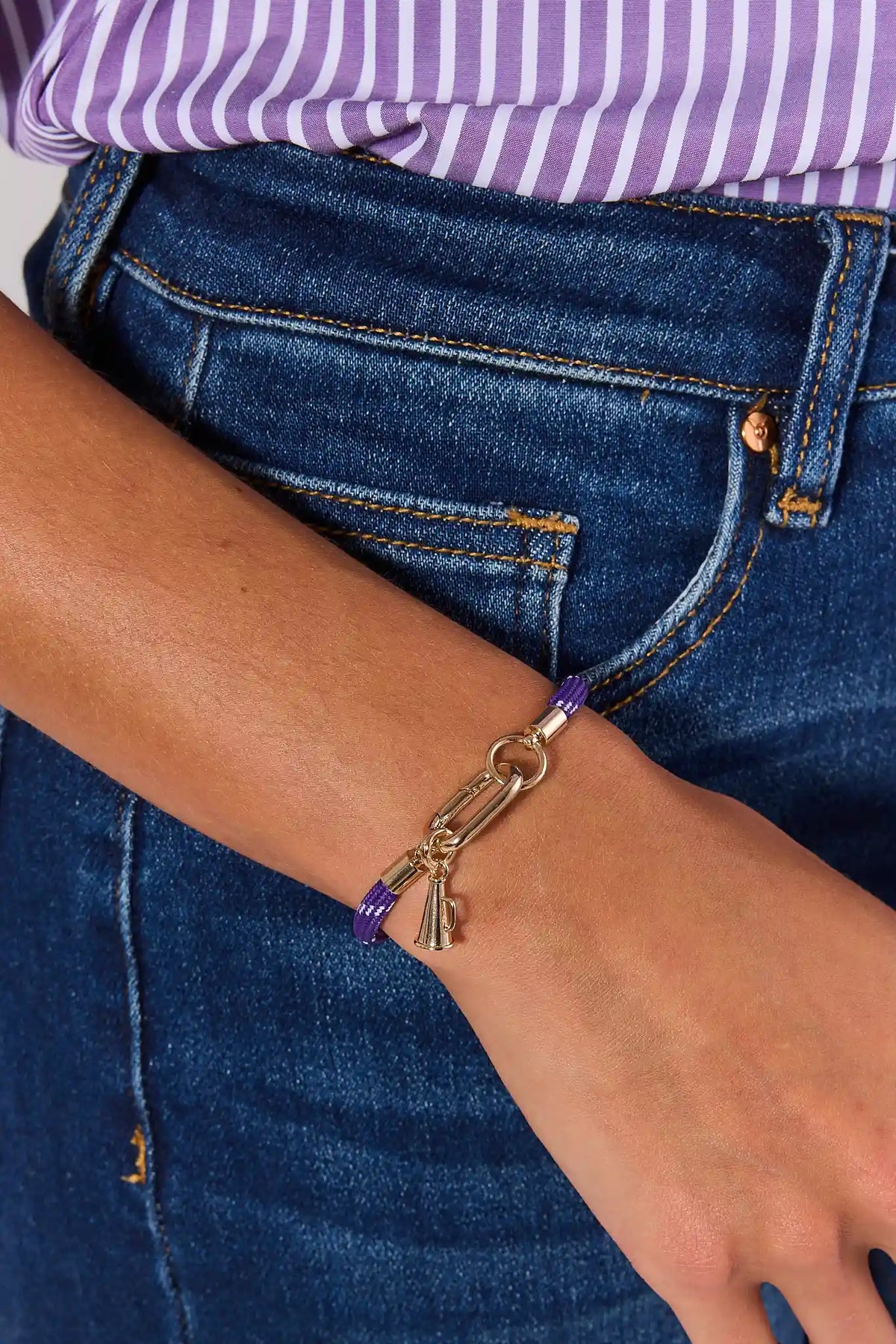 Gold megaphone charm on purple rope bracelet worn on wrist with denim - game day outfit accessory | Avara