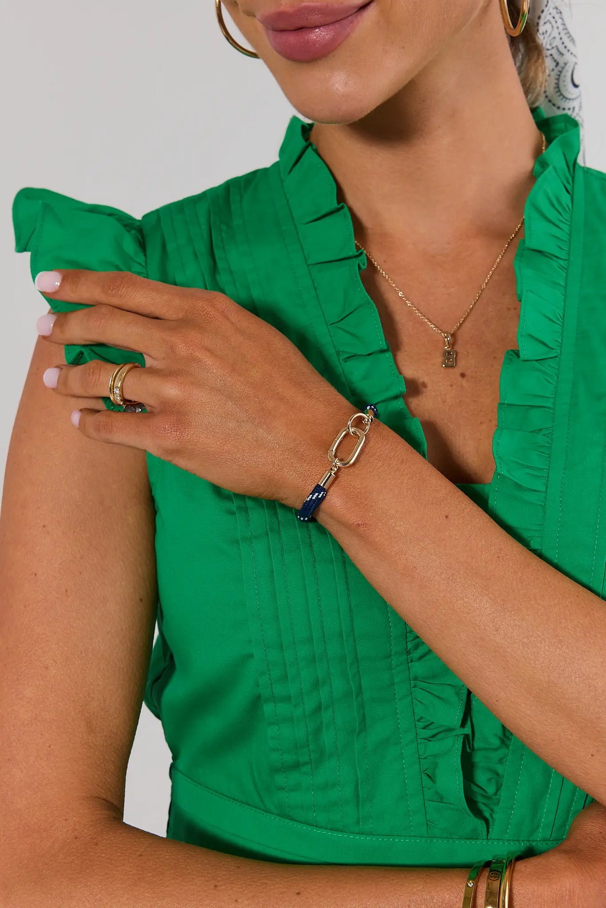 Blue cord carabiner bracelet with gold hardware styled on model with gold rings and necklace | Avara