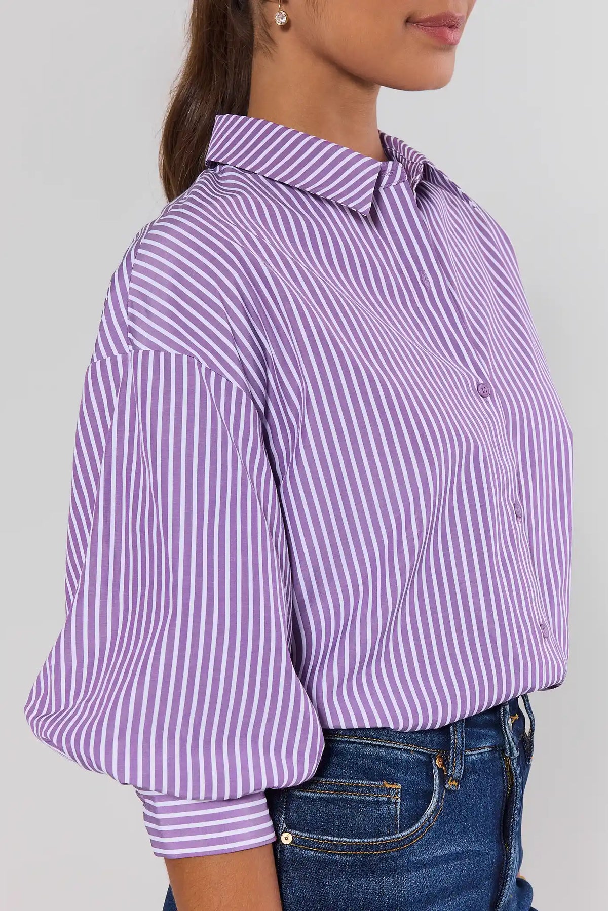 Purple striped button-up top side view showing puff sleeve and banded cuff detail, styled with denim | Avara
