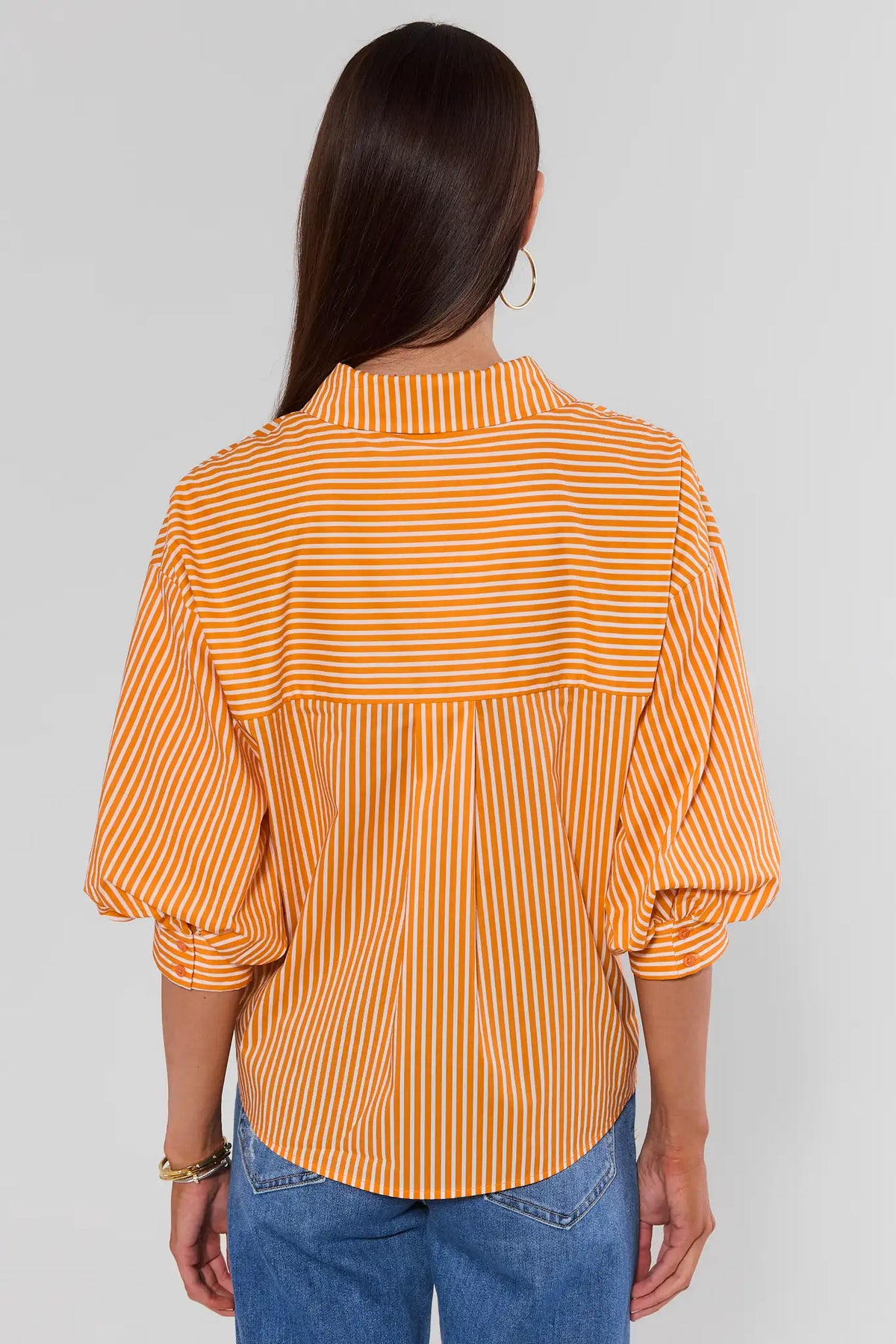 Orange striped button-up shirt back view showing puff sleeves and back yoke detail, paired with blue jeans | Avara