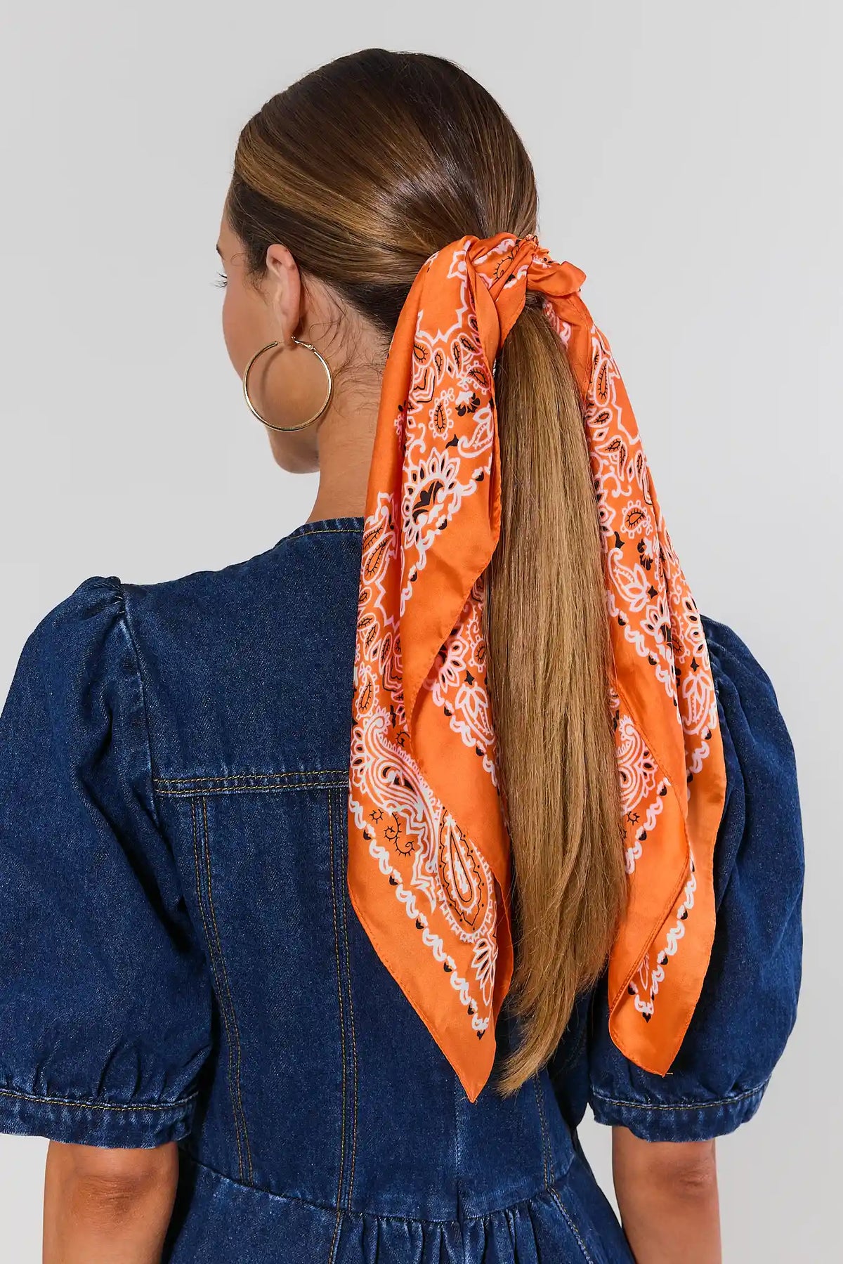 Orange bandana scarf tied around ponytail, styled with blue denim puff-sleeve dress - Back View | Avara