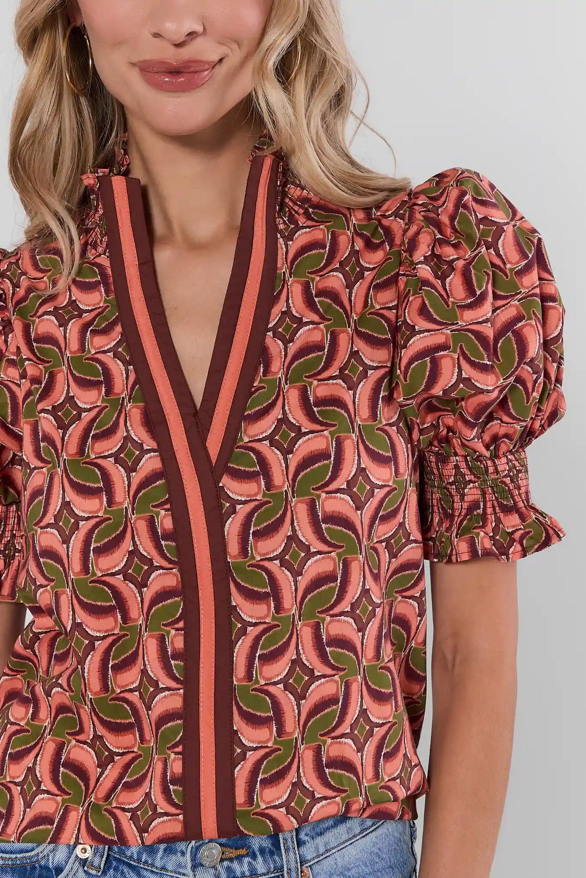 Edith Brown Printed Top close-up showing abstract print, contrast V-trim, and smocked ruffle cuffs - Detail View | Avara