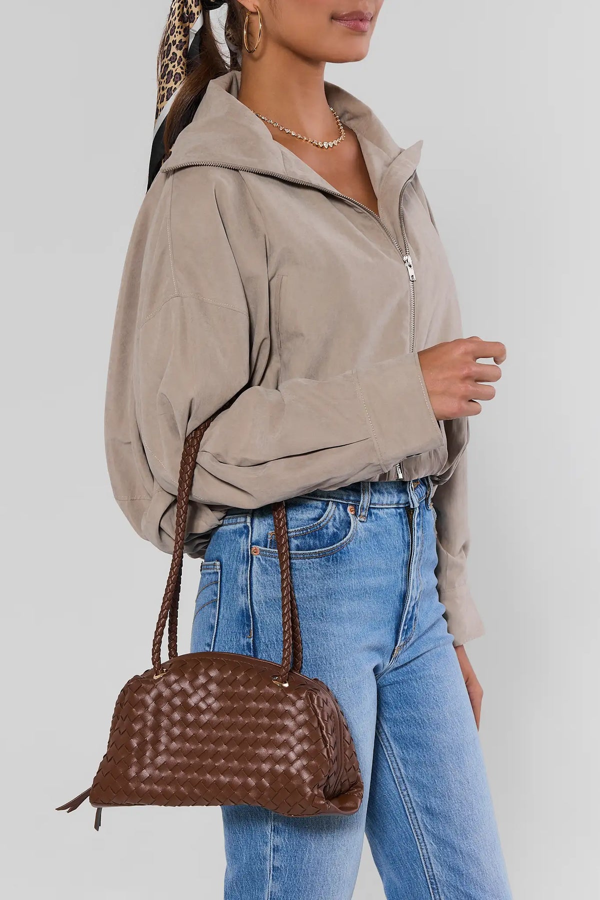 Woman in taupe jacket and jeans carrying brown woven shoulder bag with braided straps - On Model | Avara