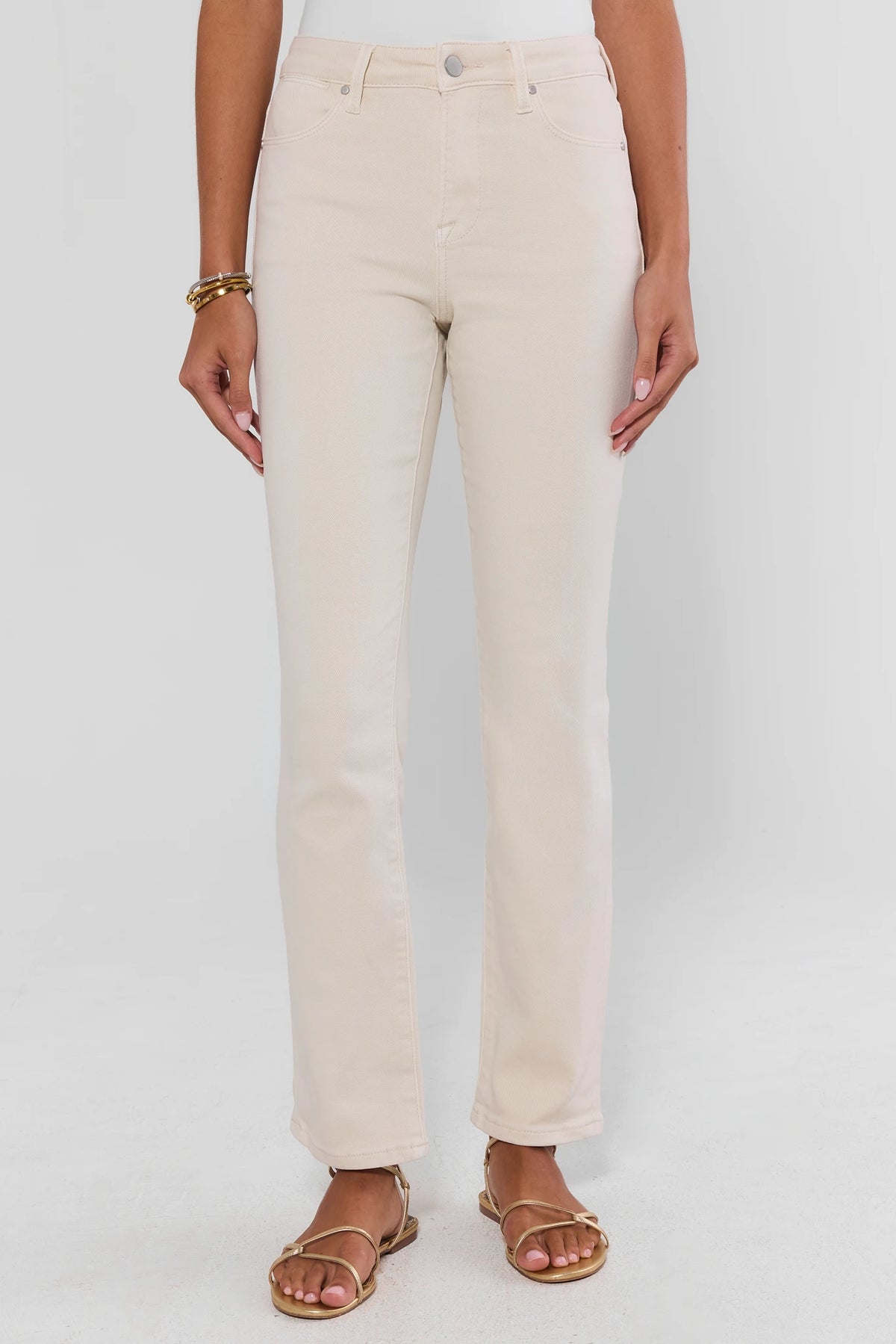Ecru straight leg jeans on model, high-rise with silver button fly and gold strappy sandals - Front View | Avara