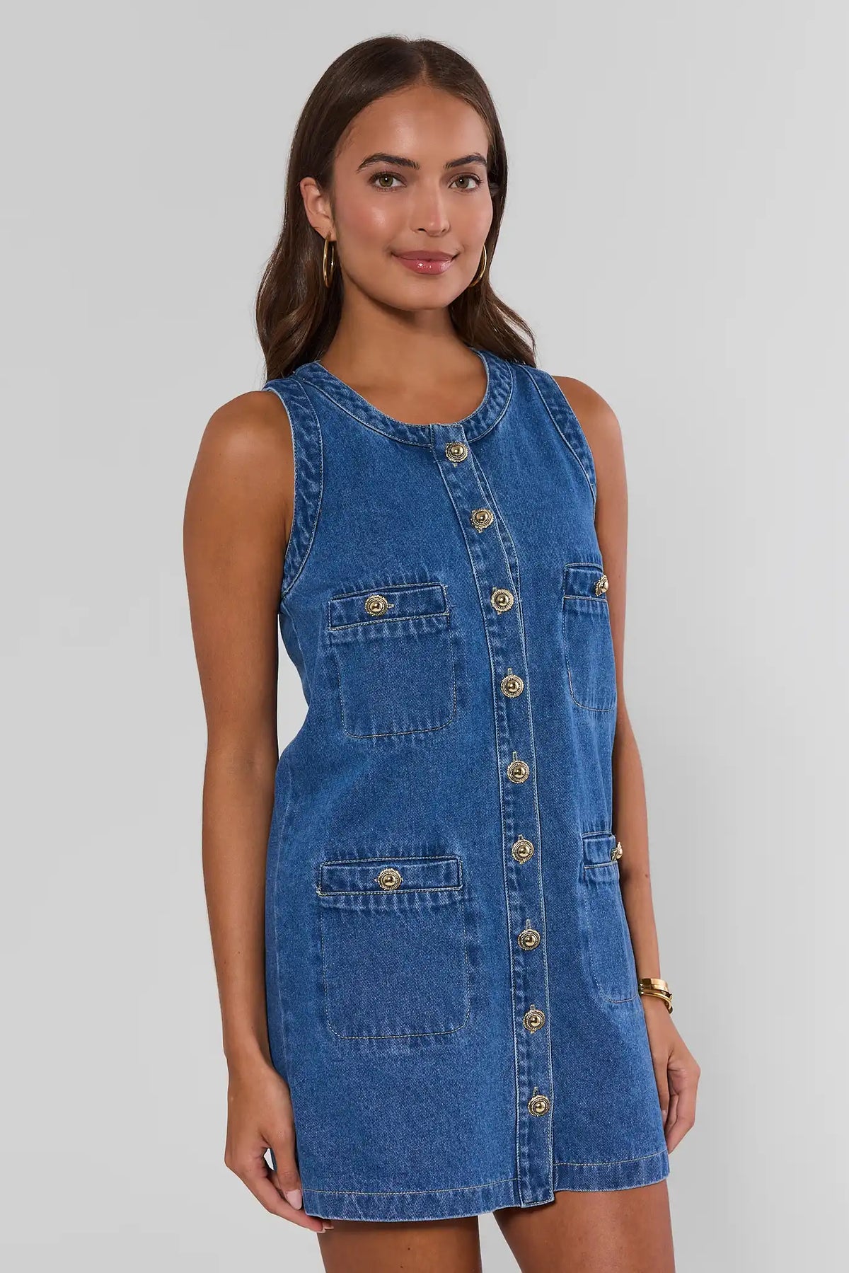 Blue denim short dress with gold button-front detail and four patch pockets - Side Angle View | Avara