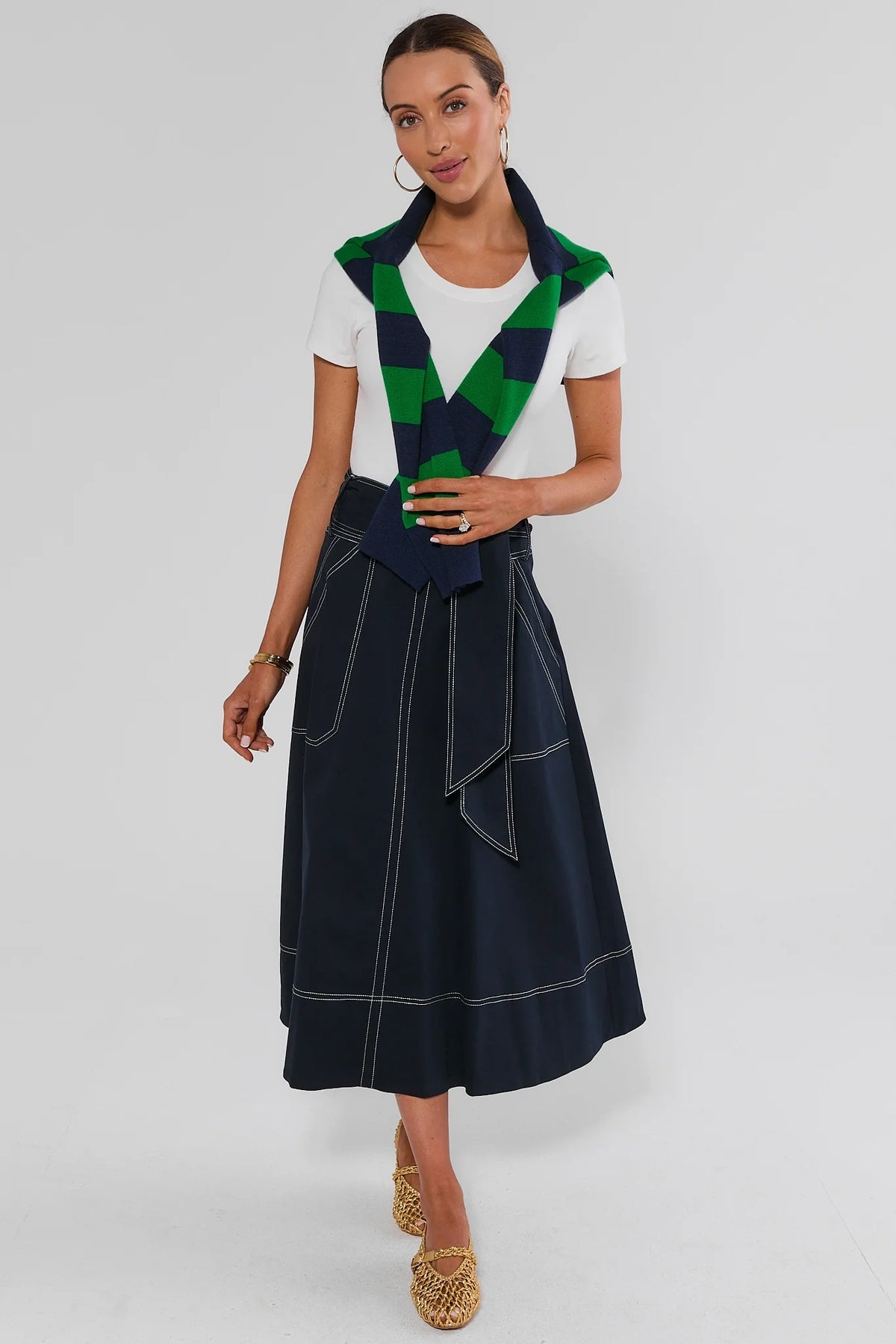 Charlotte Tie Waist Midi Skirt in navy styled with white tee and green striped sweater draped over shoulders | Avara