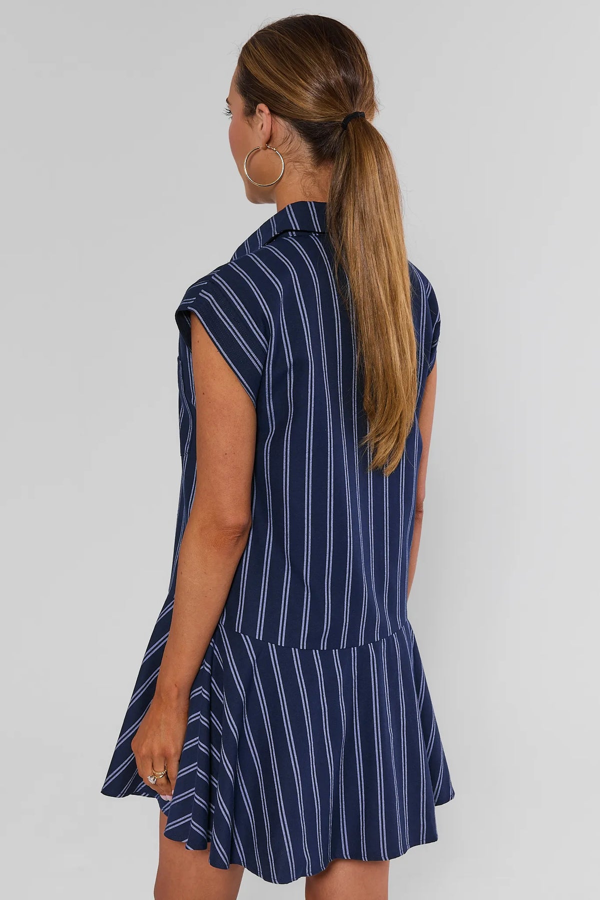 Back view of navy striped drop-waist short dress showing flared hem and collar detail - Eliana | Avara
