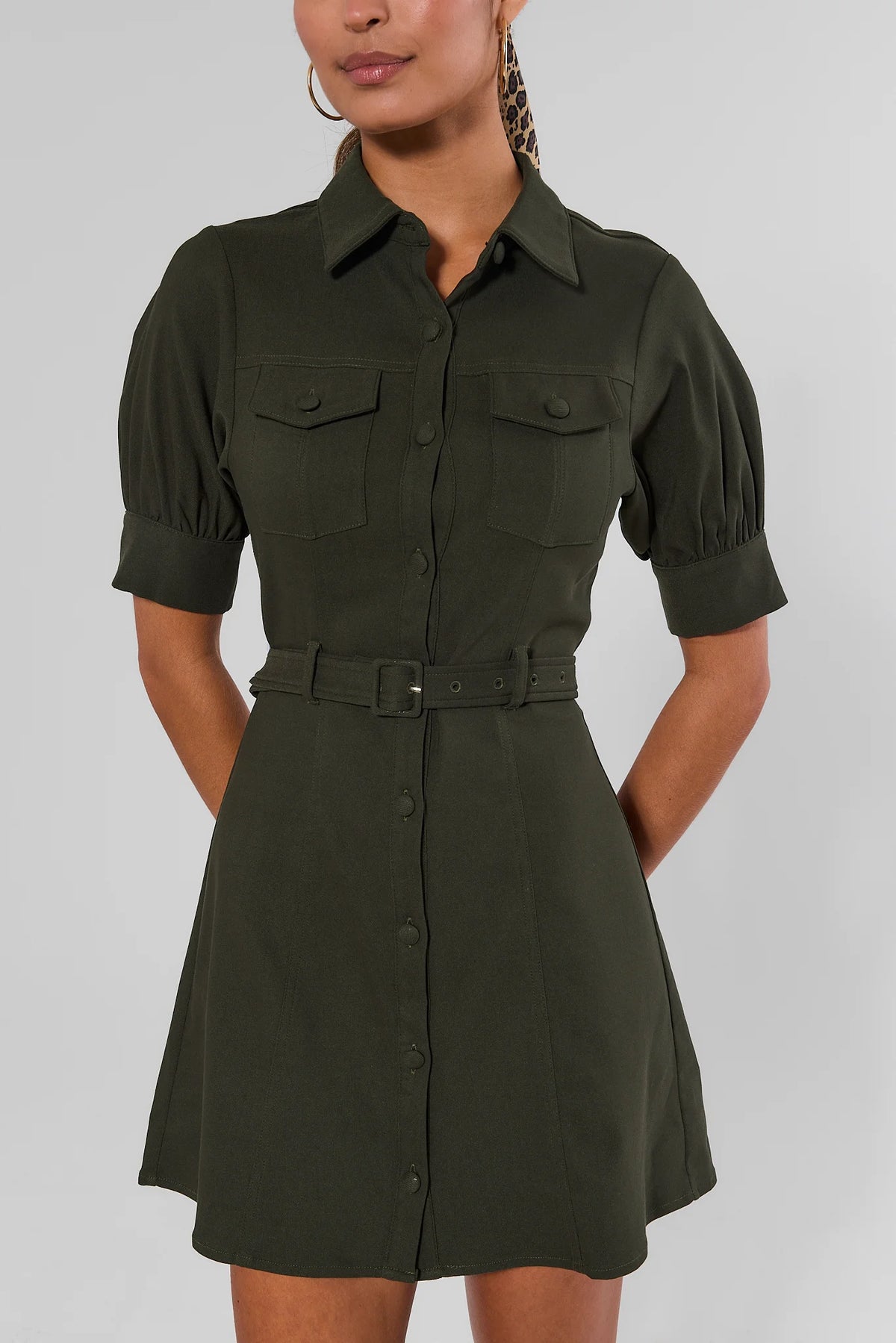 Close-up of olive green belted button-down dress showing collar, puff sleeves, chest flap pockets, and matching belt | Avara