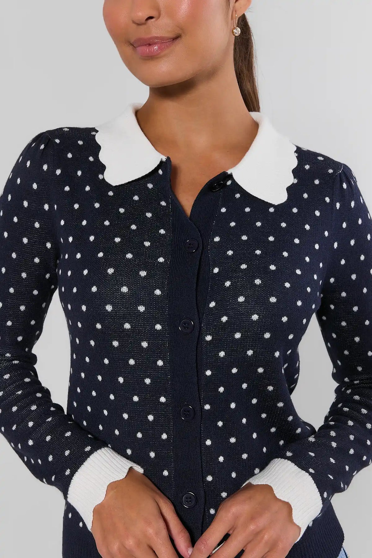Navy blue polka dot cardigan with contrast white scalloped collar and button front - Close-Up Detail | Avara