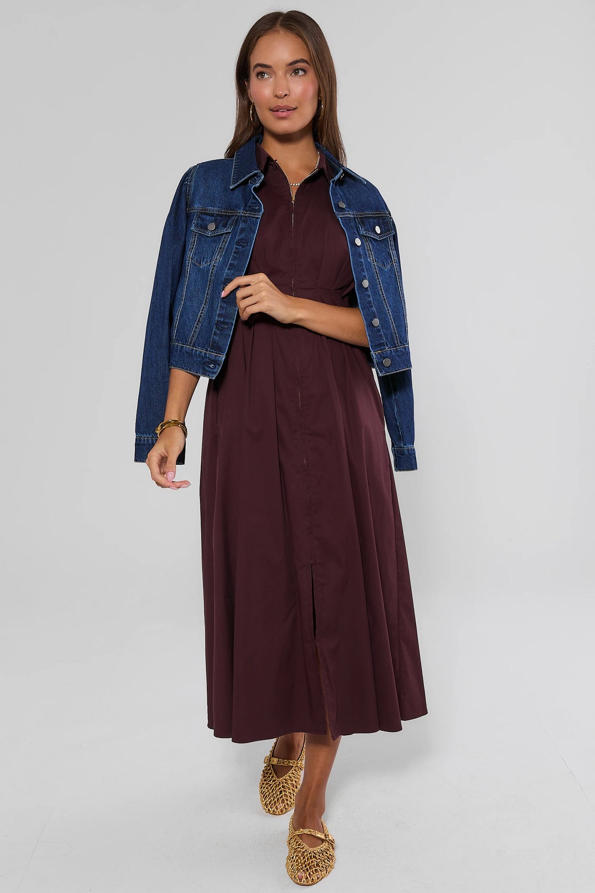 Burgundy zip-up midi dress layered under blue denim jacket with woven flats, styled look | Avara