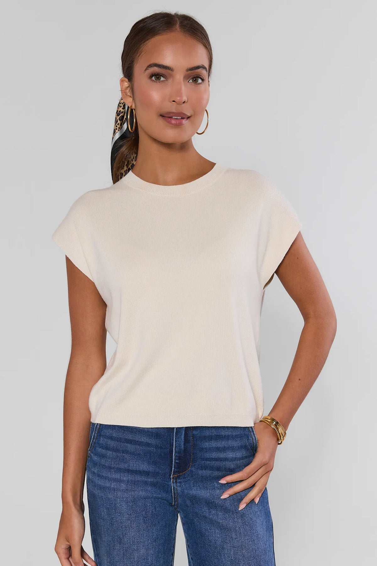 Ivory Knit Crewneck Top on model, front view, styled with blue jeans and gold hoop earrings | Avara