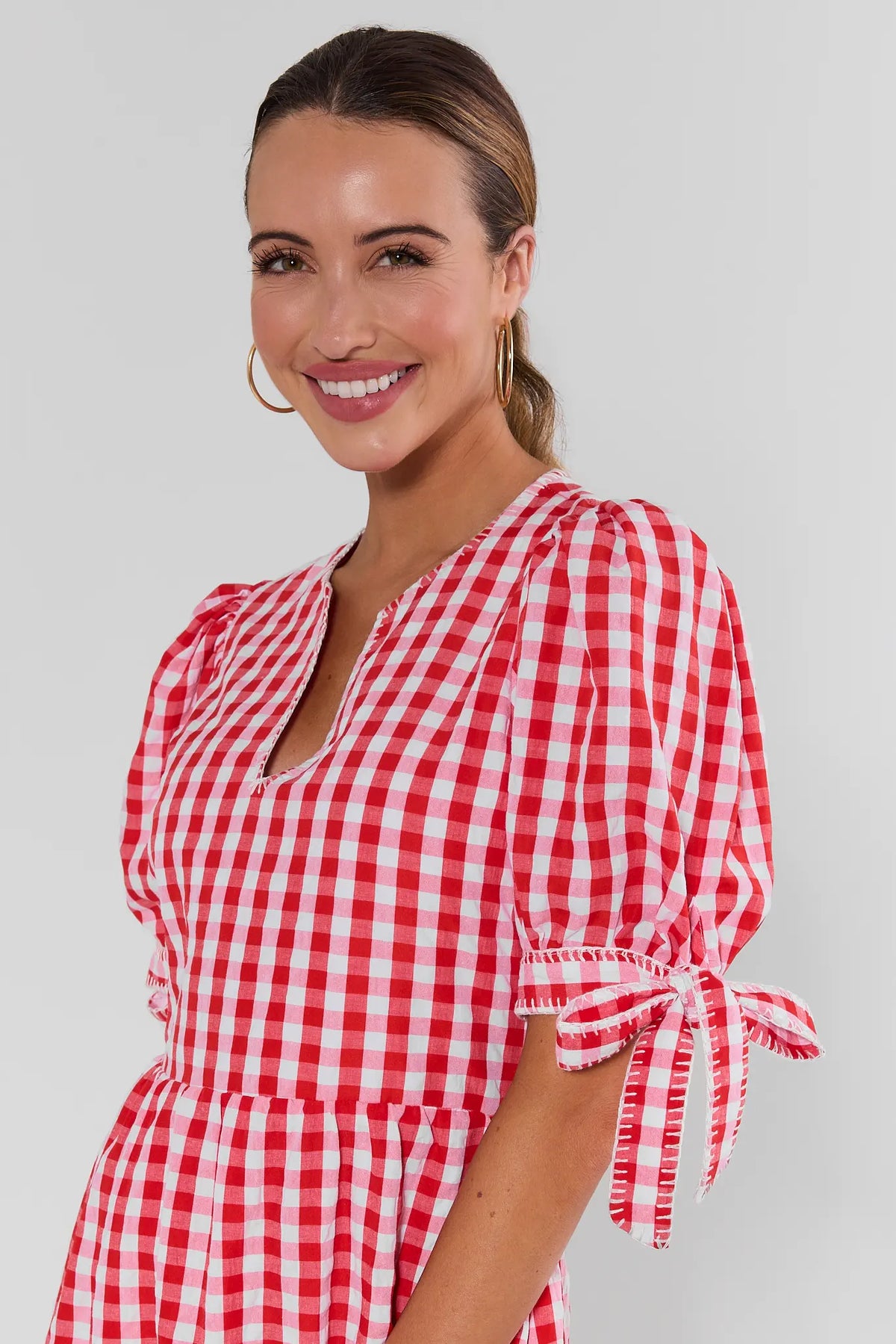 Hazel Red Gingham Midi Dress close-up showing puff sleeves with tie cuffs and notched neckline detail | Avara