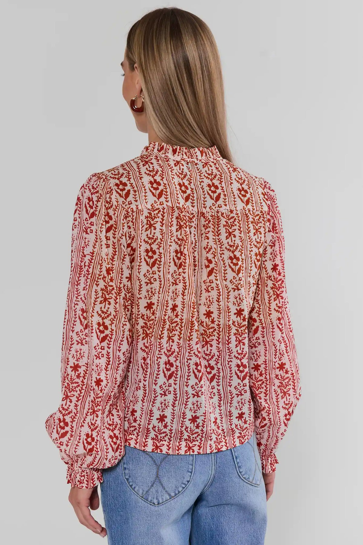 Woman shown from back wearing Red Floral Printed Button Up Top with allover floral print, paired with blue jeans | Avara
