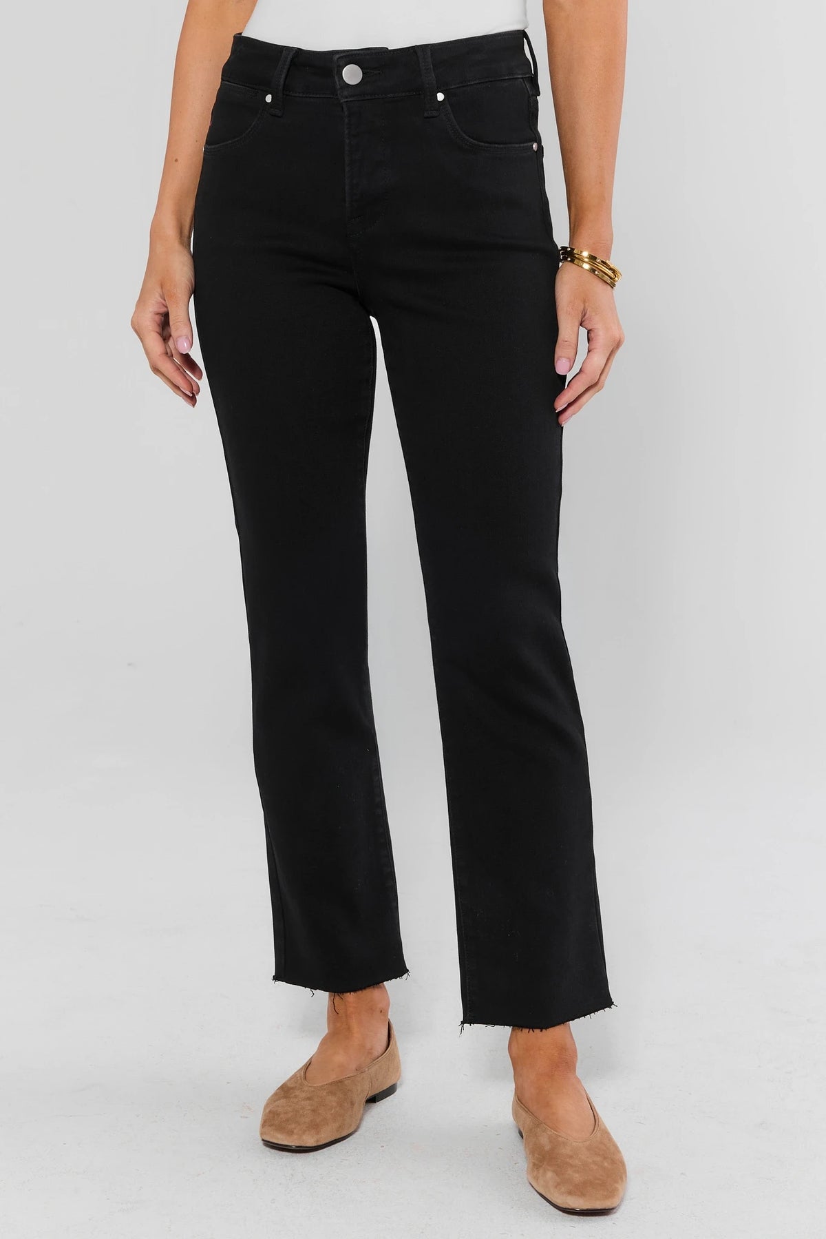 Black cropped kick flare jeans with raw hem, paired with tan suede flats - Front View On Model | Avara