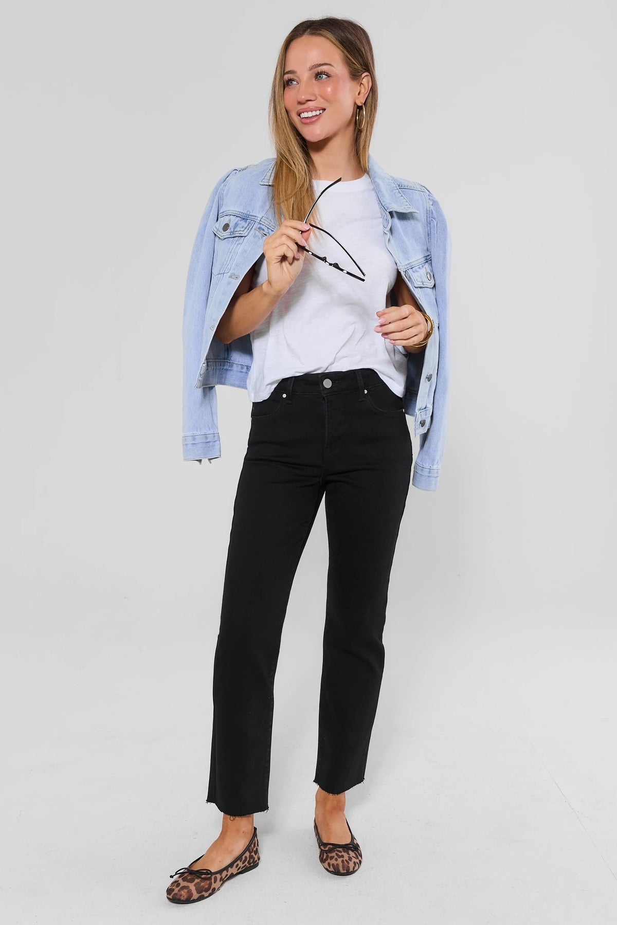 Becca Black Kick Flare Cropped Jeans styled with white tee and light-wash denim jacket - Full Length On Model | Avara