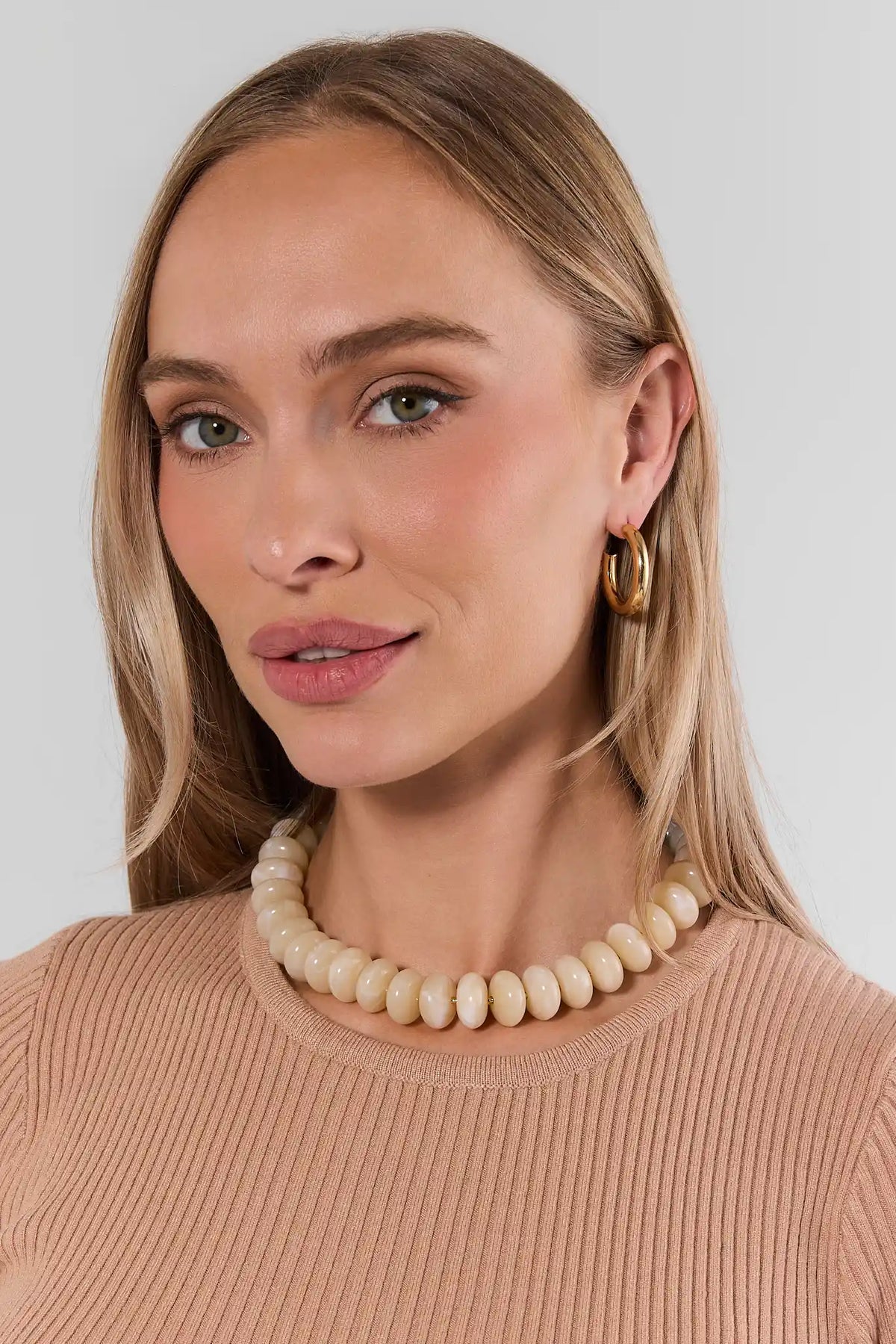 Tan Chunky Beaded Statement Necklace On Model with Blush Ribbed Top - Front View | Avara