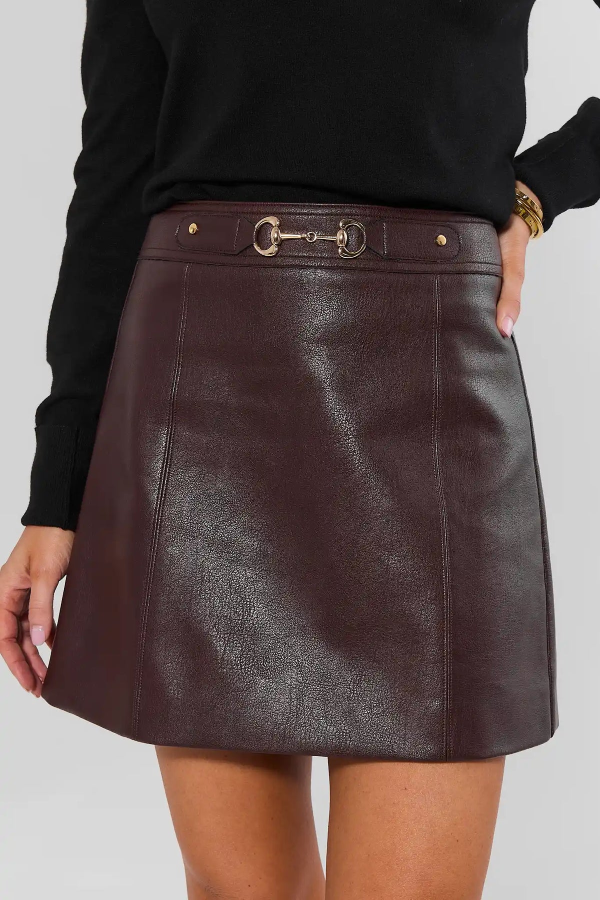 Brown Faux Leather Mini Skirt with Gold Horsebit Detail - Front Close-Up View | Avara