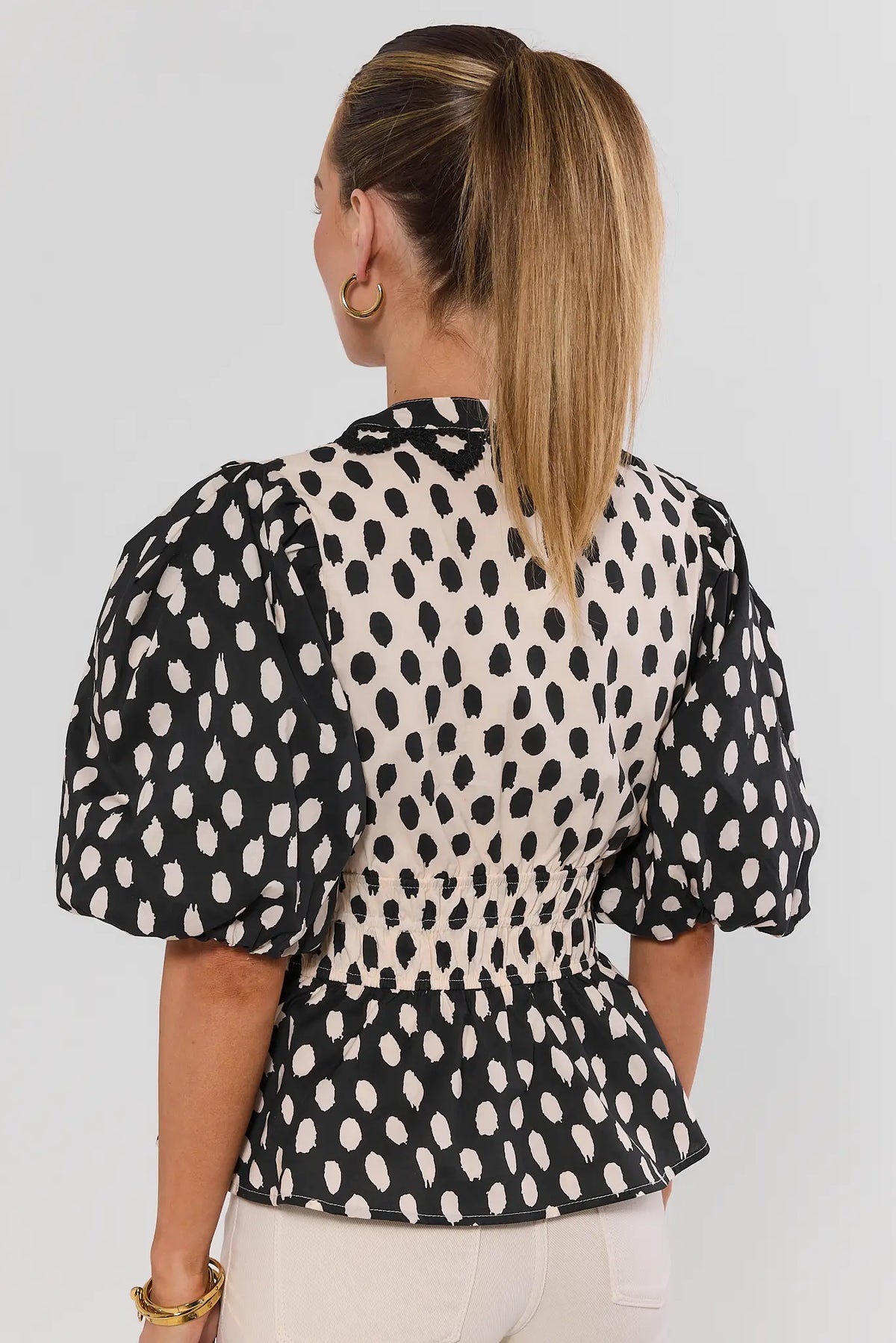 Black Contrast Polka Dot Peplum Top - Back View Showing Smocked Waist Detail | Avara