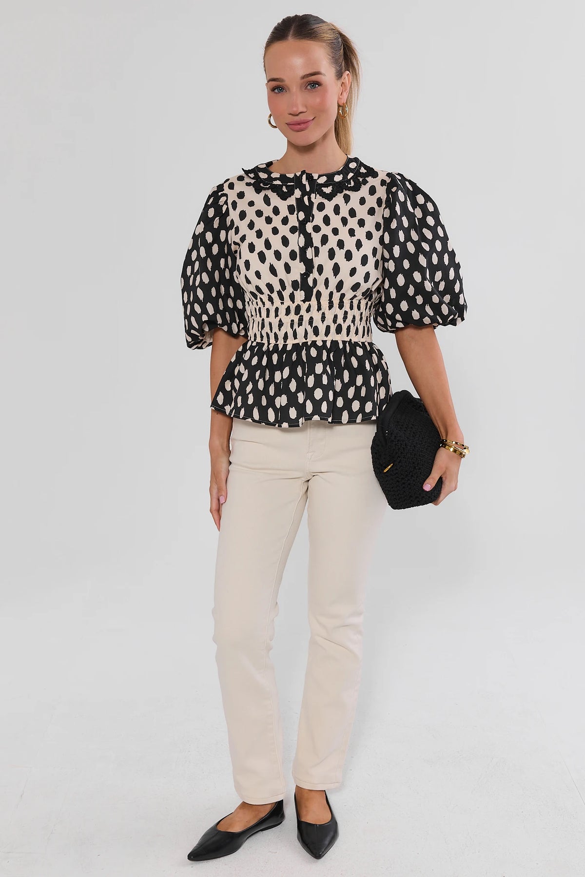 Black & Cream Polka Dot Peplum Top - Full-Length Front View, Styled with Cream Pants | Avara