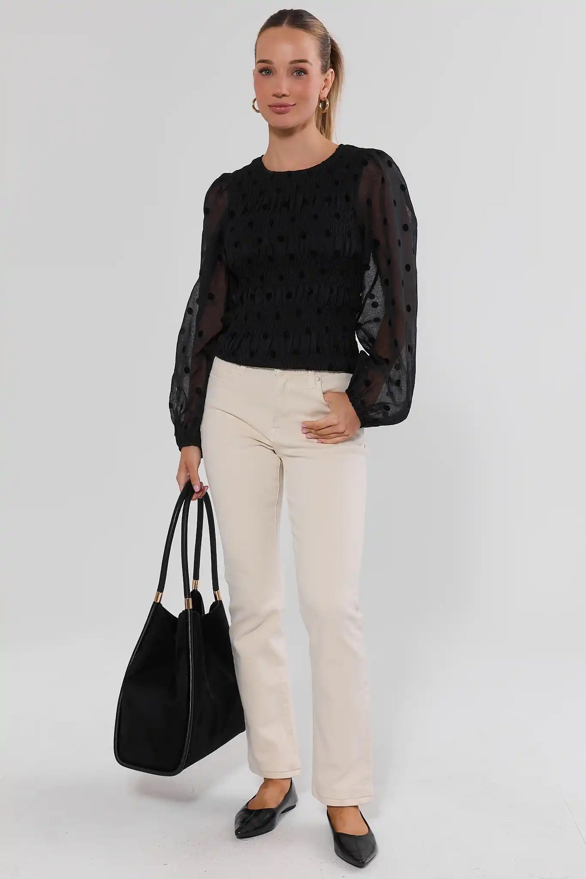 Black Polka Dot Smocked Top Styled with Cream Pants and Black Tote - Full Body | Avara