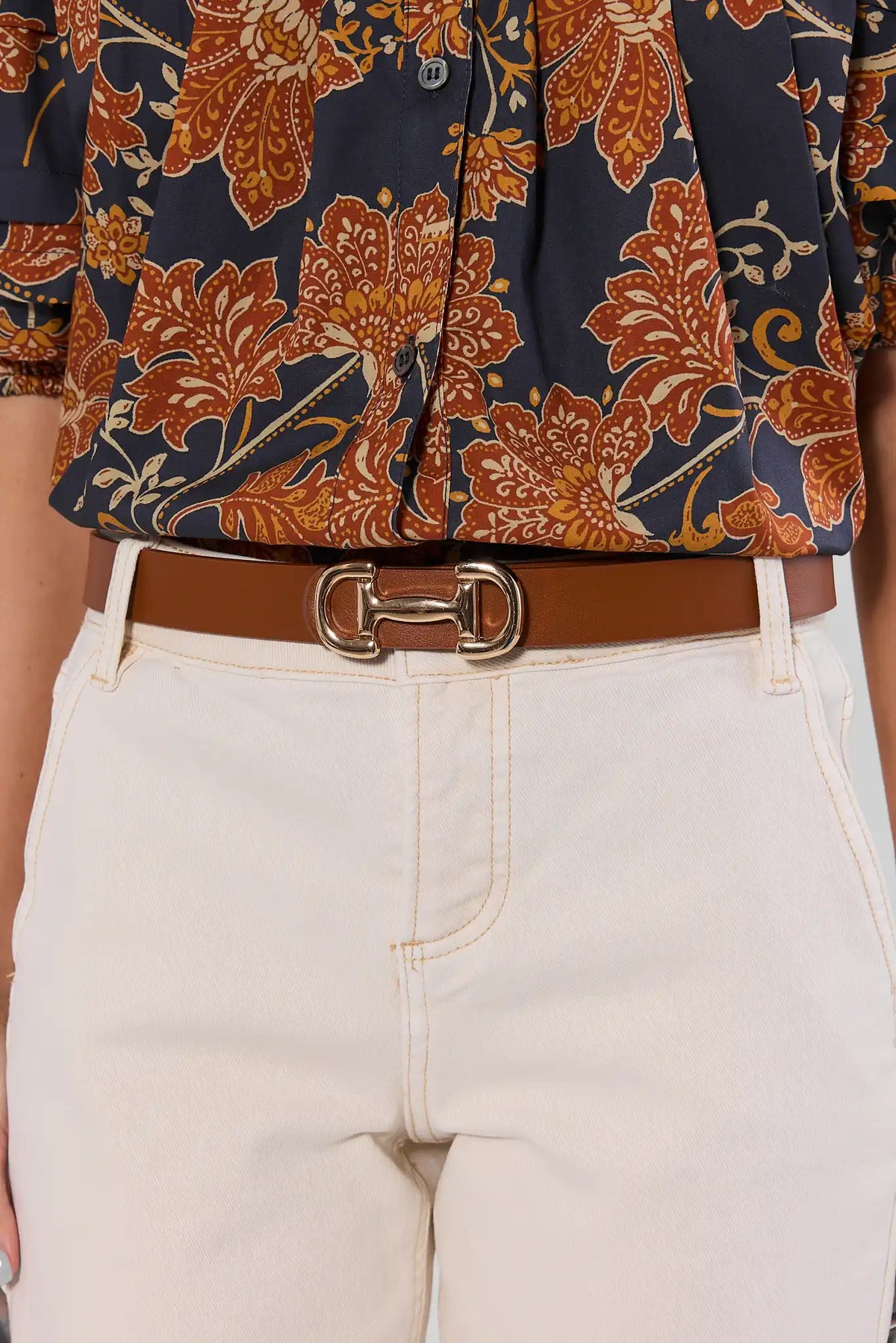 Brown Horsebit Belt Styled On Model with White Jeans and Floral Top | Avara