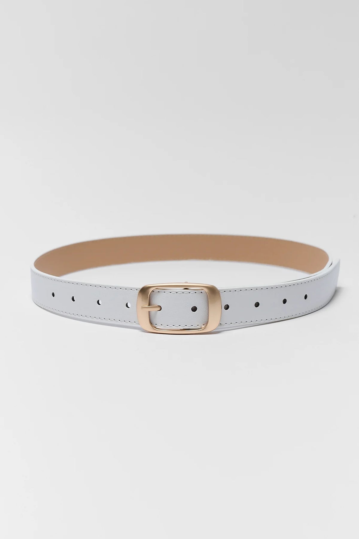 White faux leather belt with brushed gold buckle laid flat, full length view | Avara