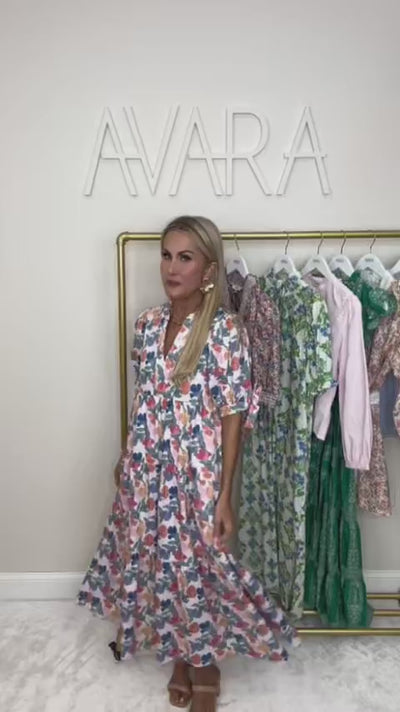 woman wearing a floral harriet dress with rack in background