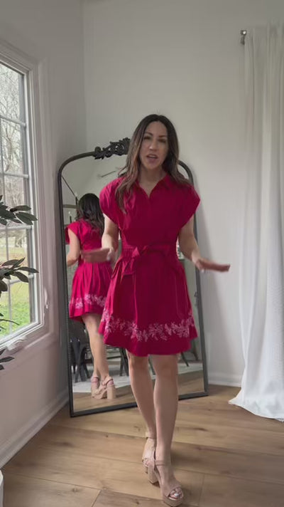 Woman wearing red paloma dress with a mirror in background