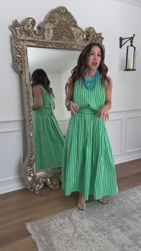 Model in green striped two piece set in front of mirror